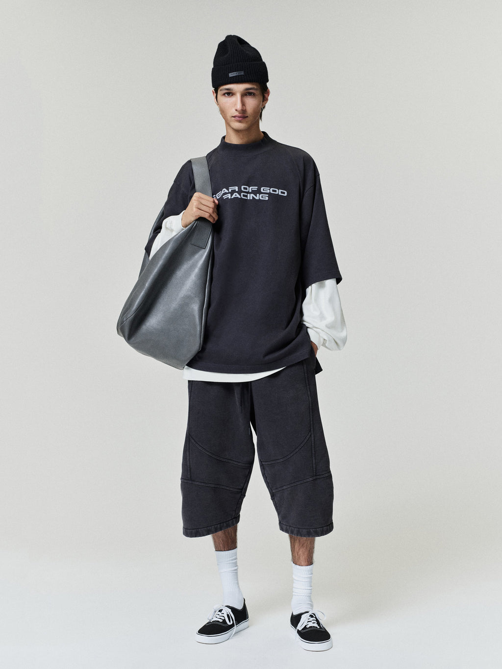 Fear of God Moto Cutoff Sweatpant shown on model in washed black with knee length cut off hems and paneled seam details Bottoms