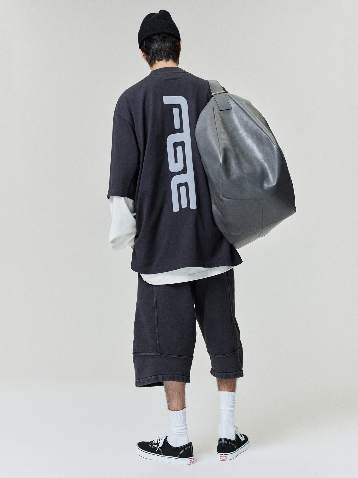Fear of God Moto Cutoff Sweatpant modeled from the back in washed black with knee length hems and structured paneled seams Bottoms
