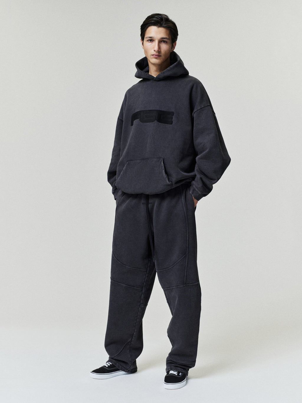 Slouchy 90s Hoodie modeled in charcoal with an oversized hood kangaroo pocket and relaxed fit styled with matching paneled sweatpants and black sneakers Tops