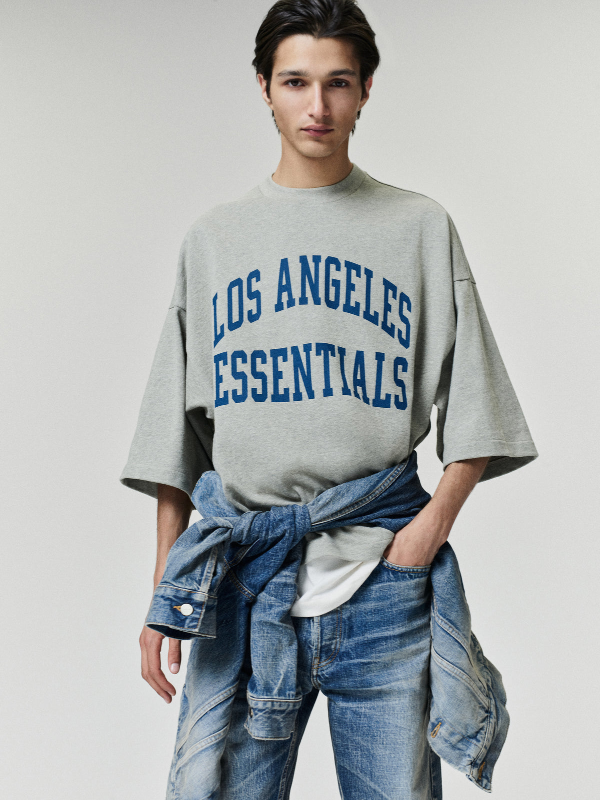 Rams Merch Tee gray oversized short sleeve T shirt with bold blue Los Angeles Essentials lettering styled on a model in a casual Tops look