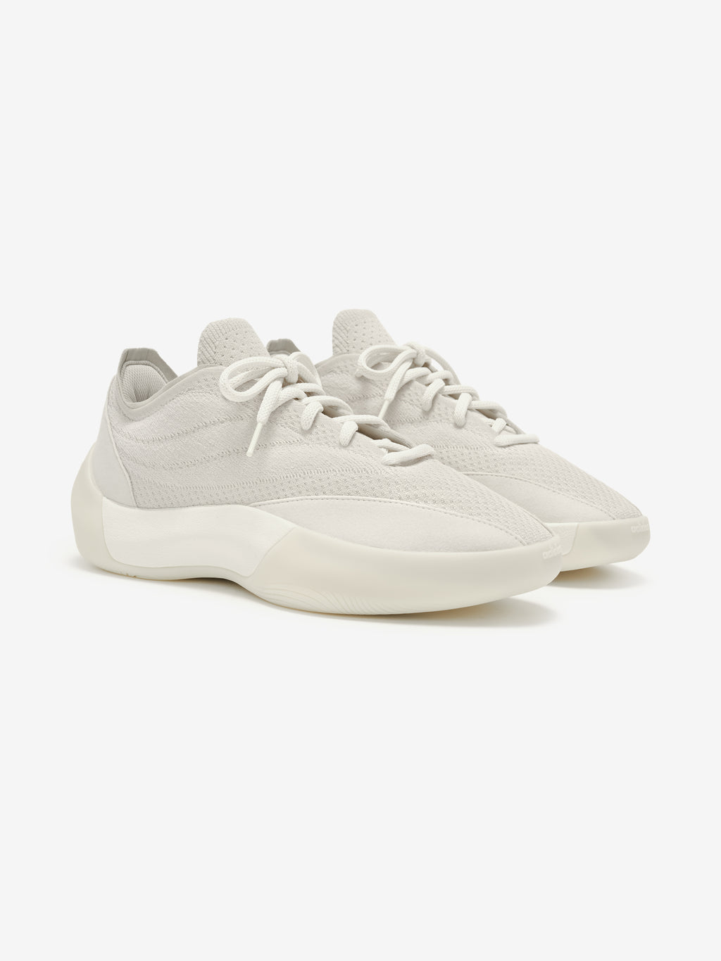 Pair of light gray sneakers with white laces on a white background