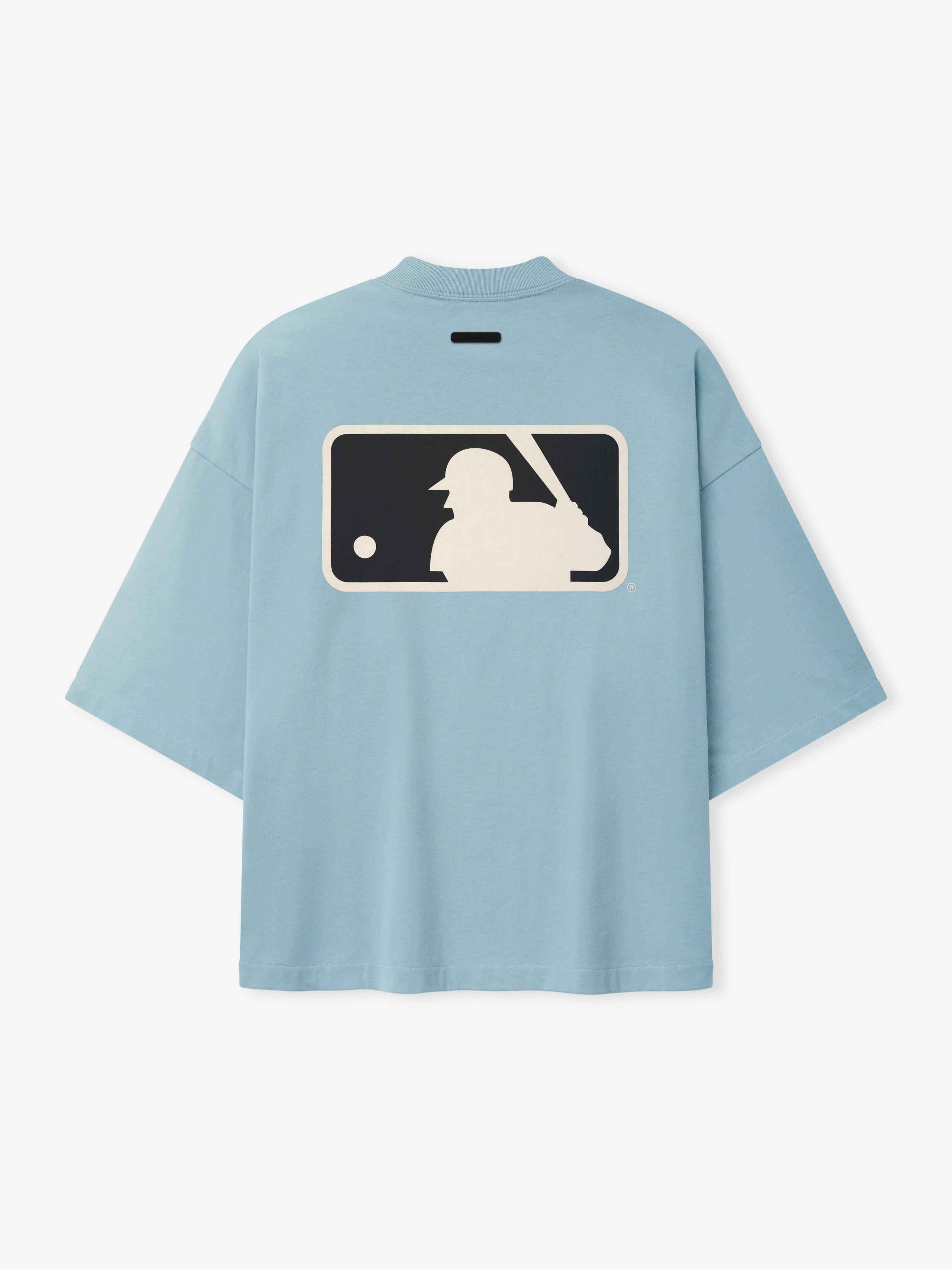 Mlb Merch Tee in soft stone blue with an oversized fit, featuring a large vintage-style baseball batter graphic in cream and navy on the back of a casual top.