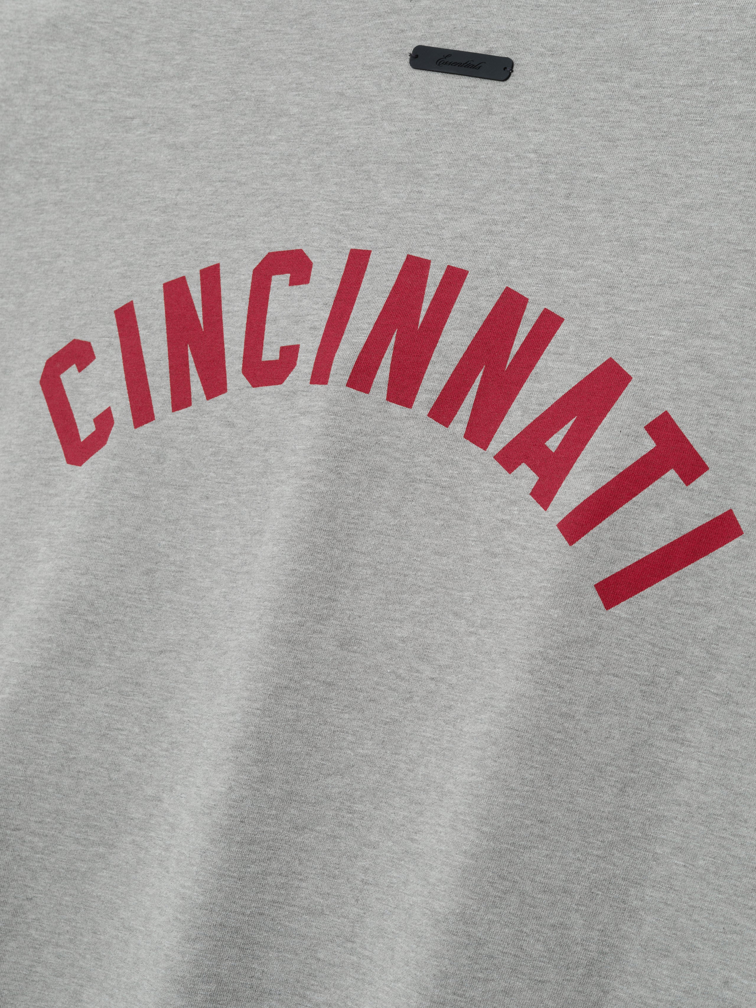 Reds Merch Tee in heather gray fabric with bold red "CINCINNATI" lettering arched across the back, crafted as a casual and comfortable top.