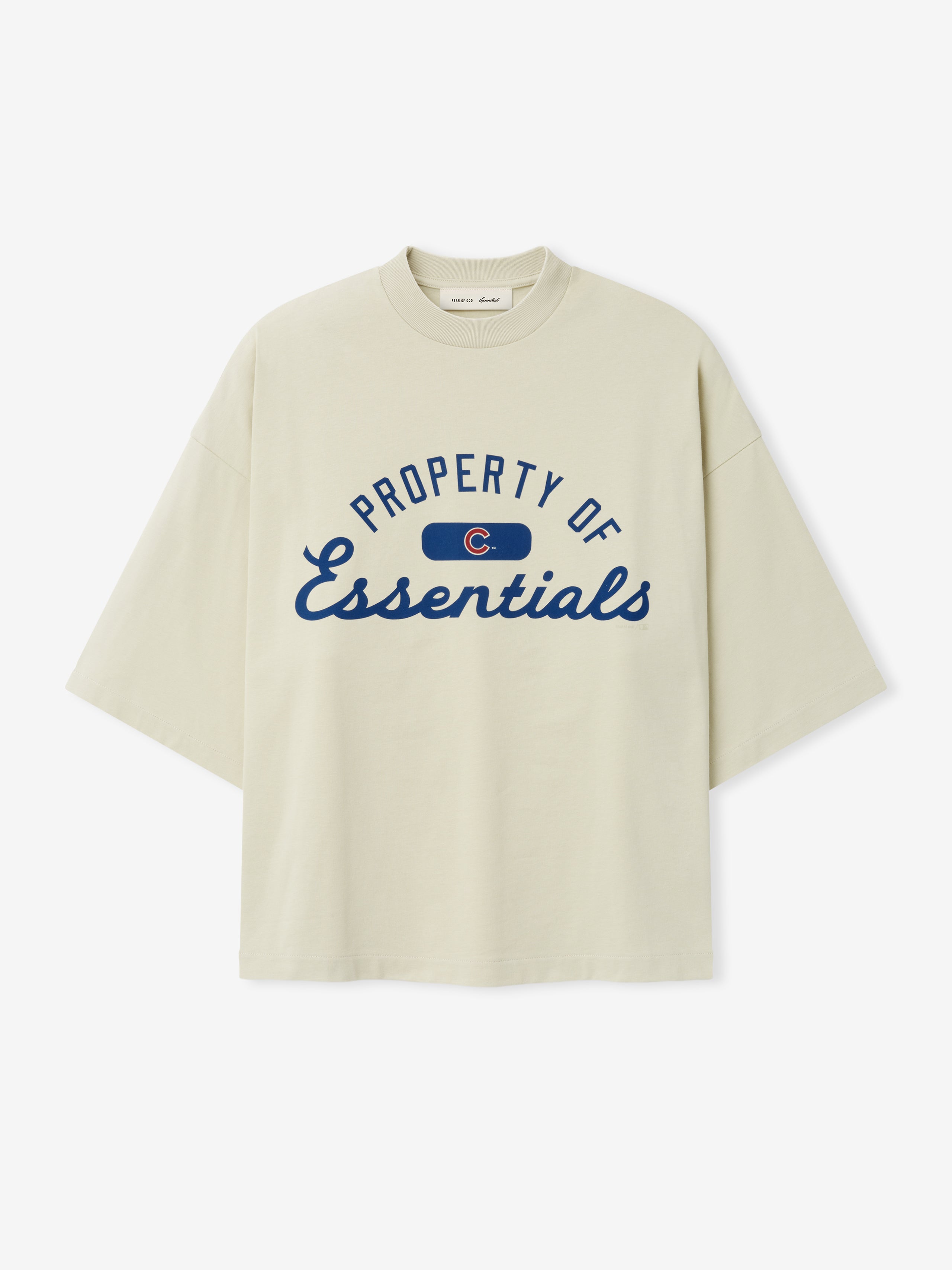 Cubs Merch Tee in a soft sandstone shade featuring navy blue "Property of Essentials" text in a classic script and block design on a comfortable cotton top.