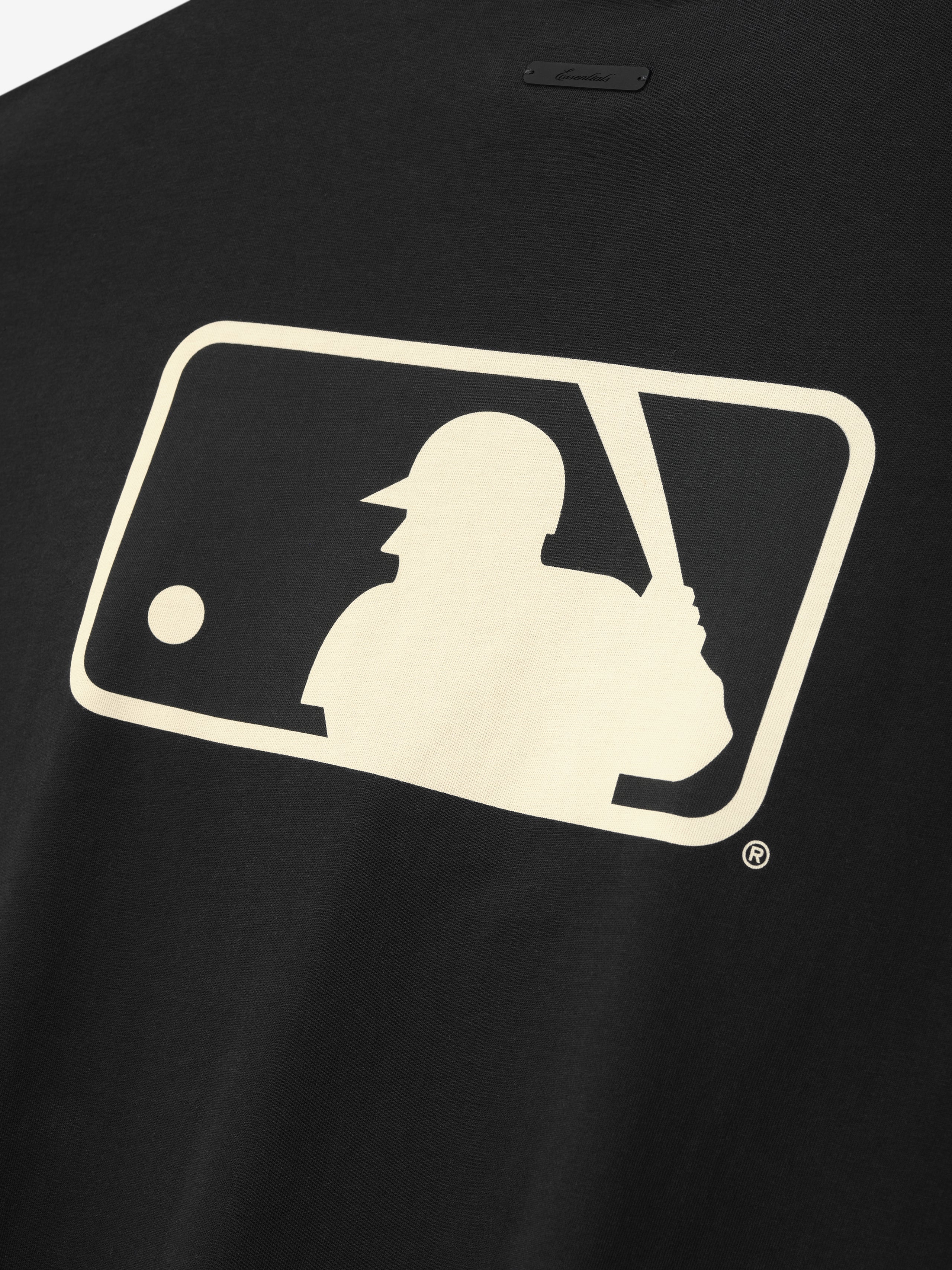 Close-up of the back of the MLB Boxy Long Sleeve Tee in black featuring a large cream-colored silhouette of a baseball batter holding a bat within a rounded rectangular frame on soft fabric.