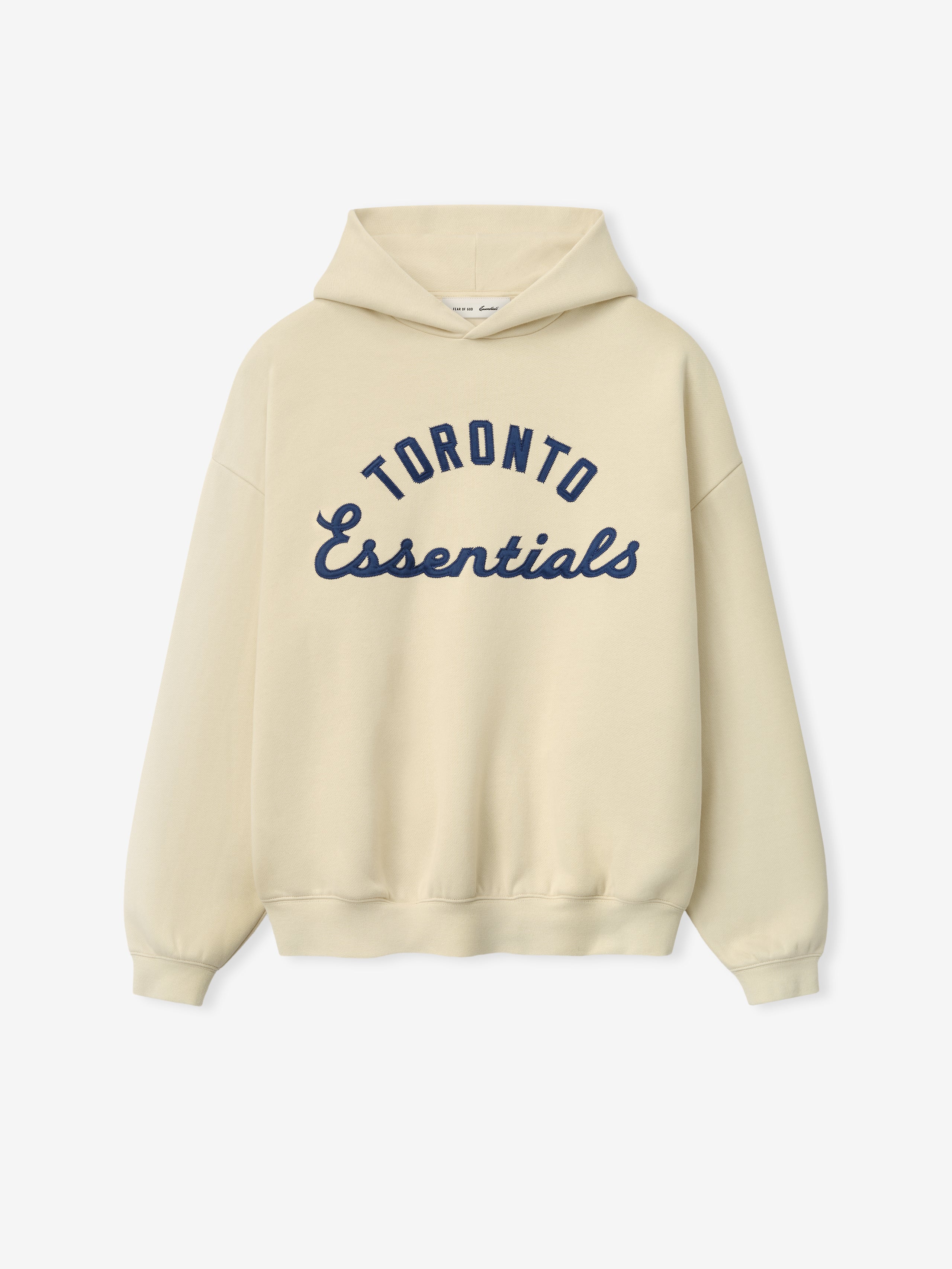 Blue Jays Sport Hoodie in a soft oatmeal shade featuring navy blue "Toronto Essentials" text in a classic script and arch design on comfortable outerwear fabric.