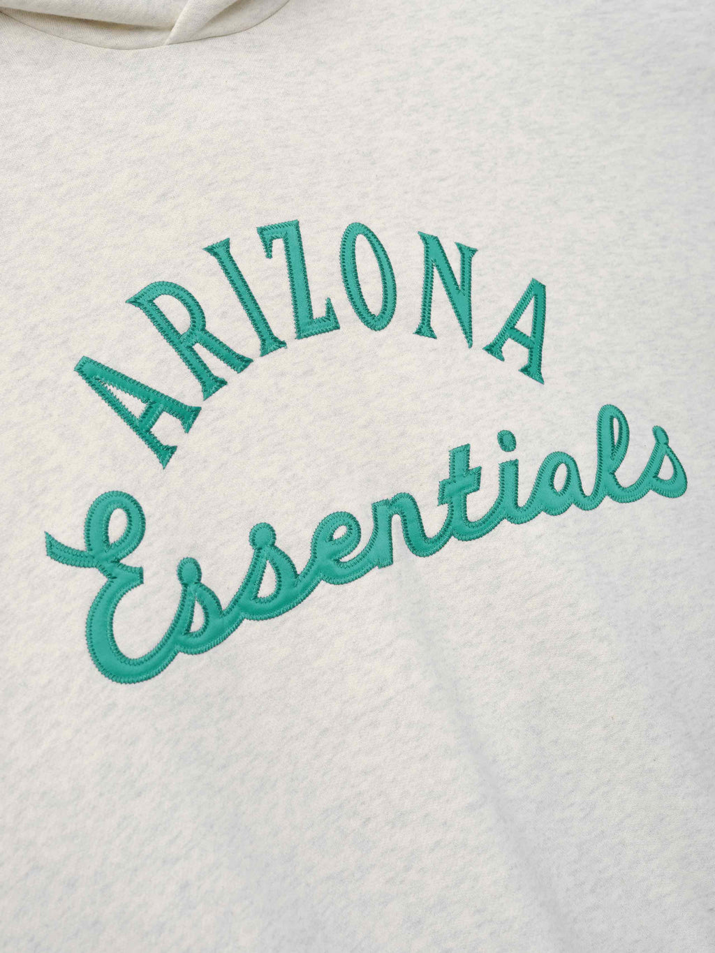 Diamondbacks Sport Hoodie in a soft oatmeal heather color featuring raised teal embroidery with "ARIZONA Essentials" text on cozy outerwear fabric.
