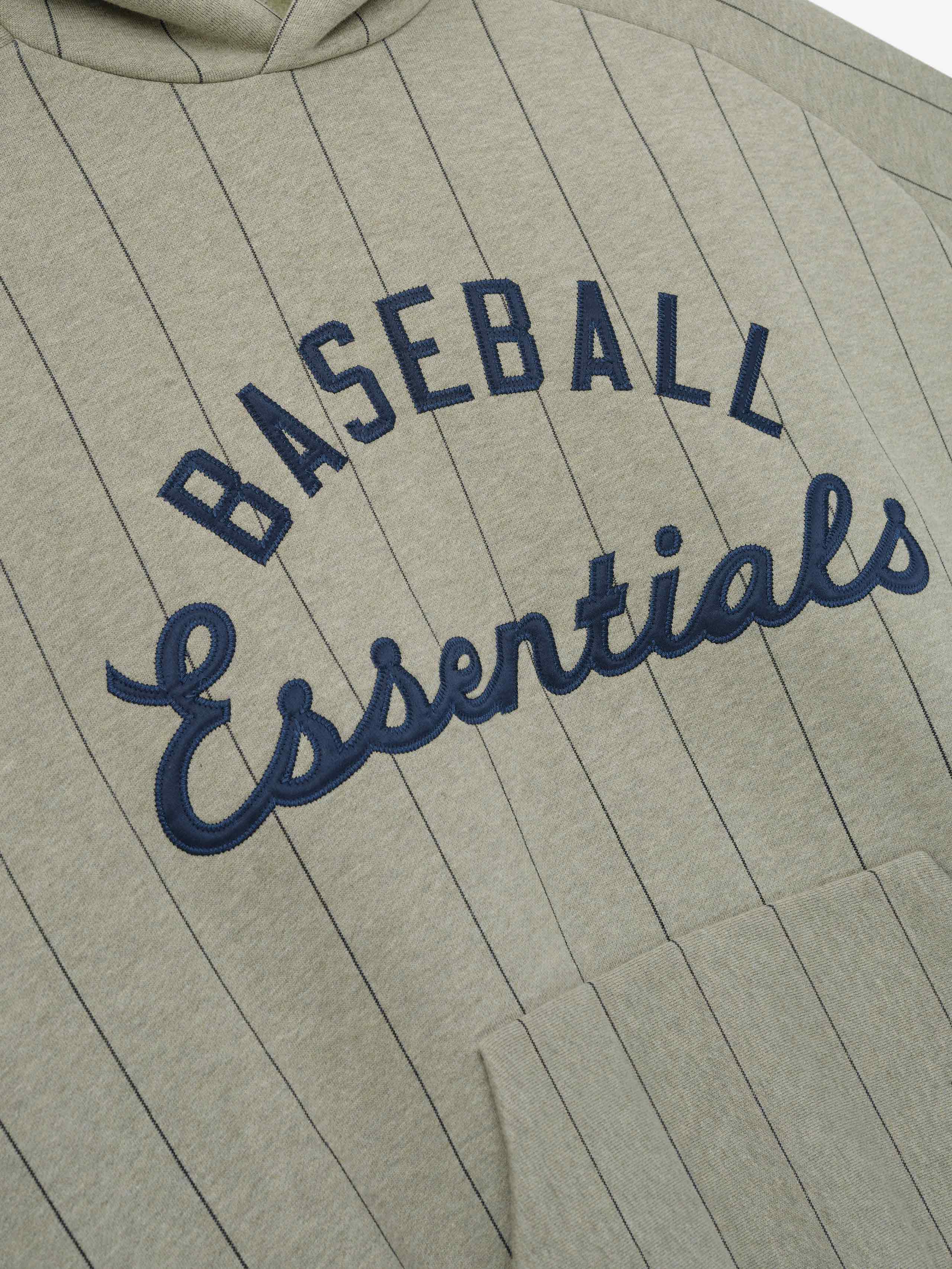 MLB Raglan Sport Hoodie in a muted seal heather shade with thin black pinstripes and navy embroidered "Baseball Essentials" text above the kangaroo pocket in soft outerwear fabric.