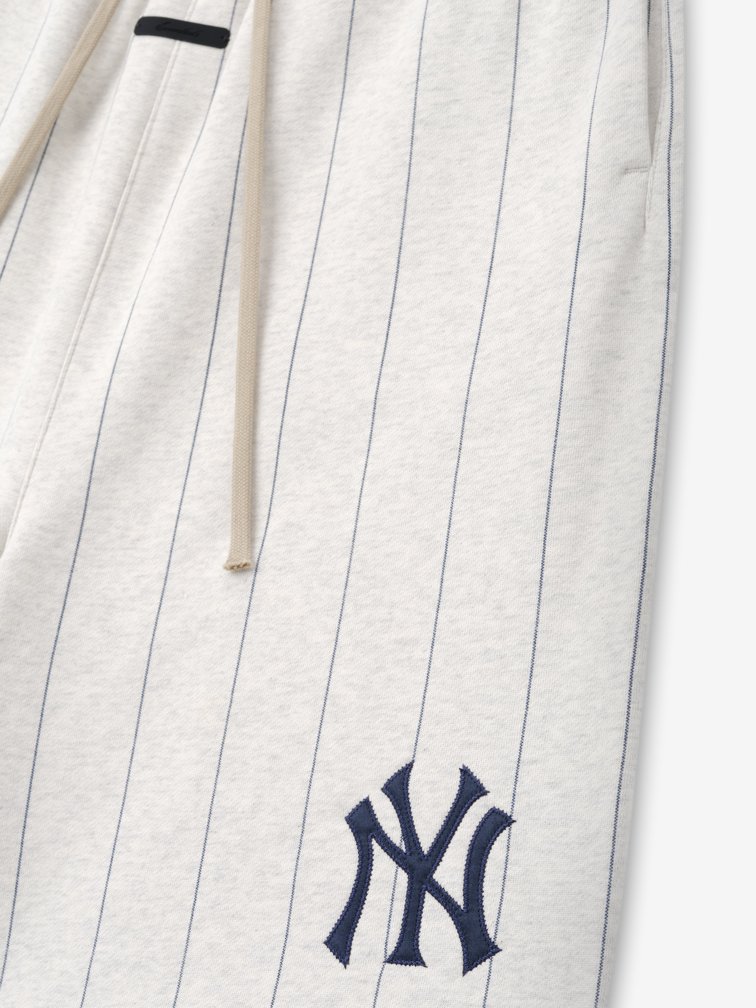 White pants with pinstripes and a blue logo on a white background