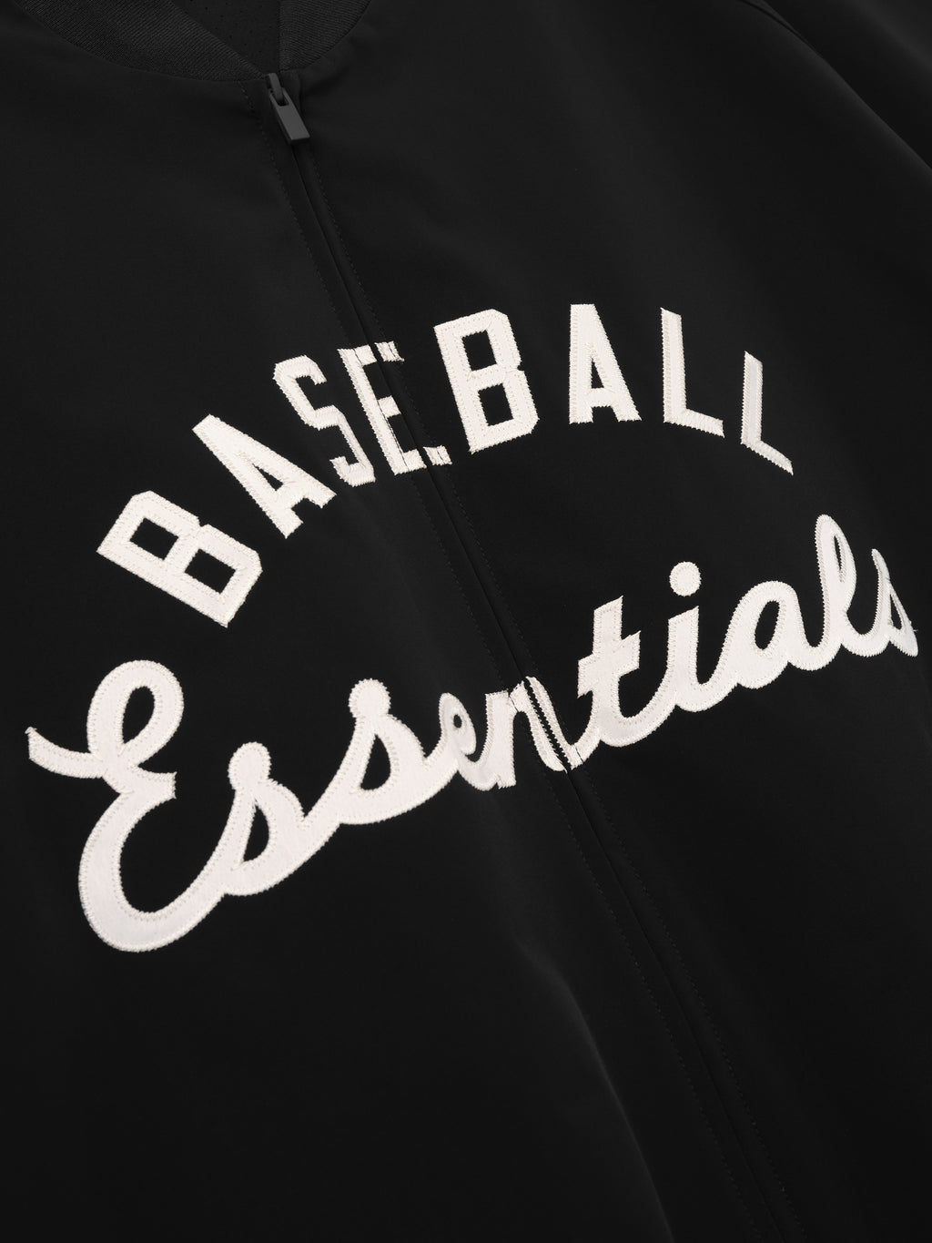 MLB Full Zip Bomber in black featuring embroidered white script reading "Baseball Essentials" in an arch design on a smooth zip-front outerwear piece.