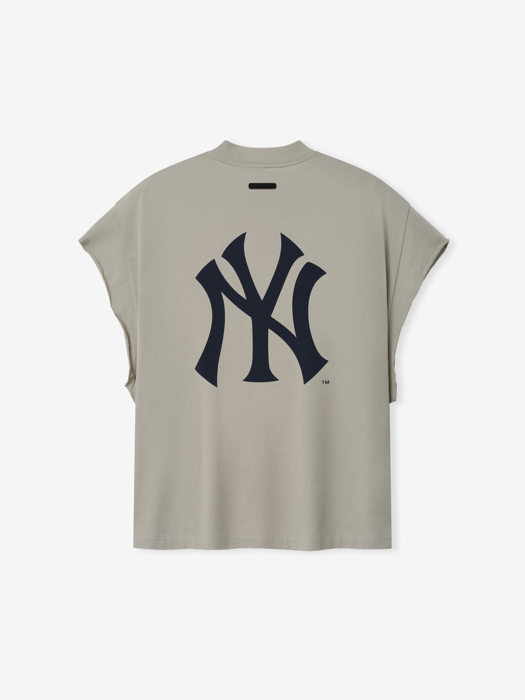Yankees 90s Cut Off in a muted beige tone featuring a sleeveless design with wide arm openings and a large, stylized navy Yankees logo printed on the back in soft cotton fabric.