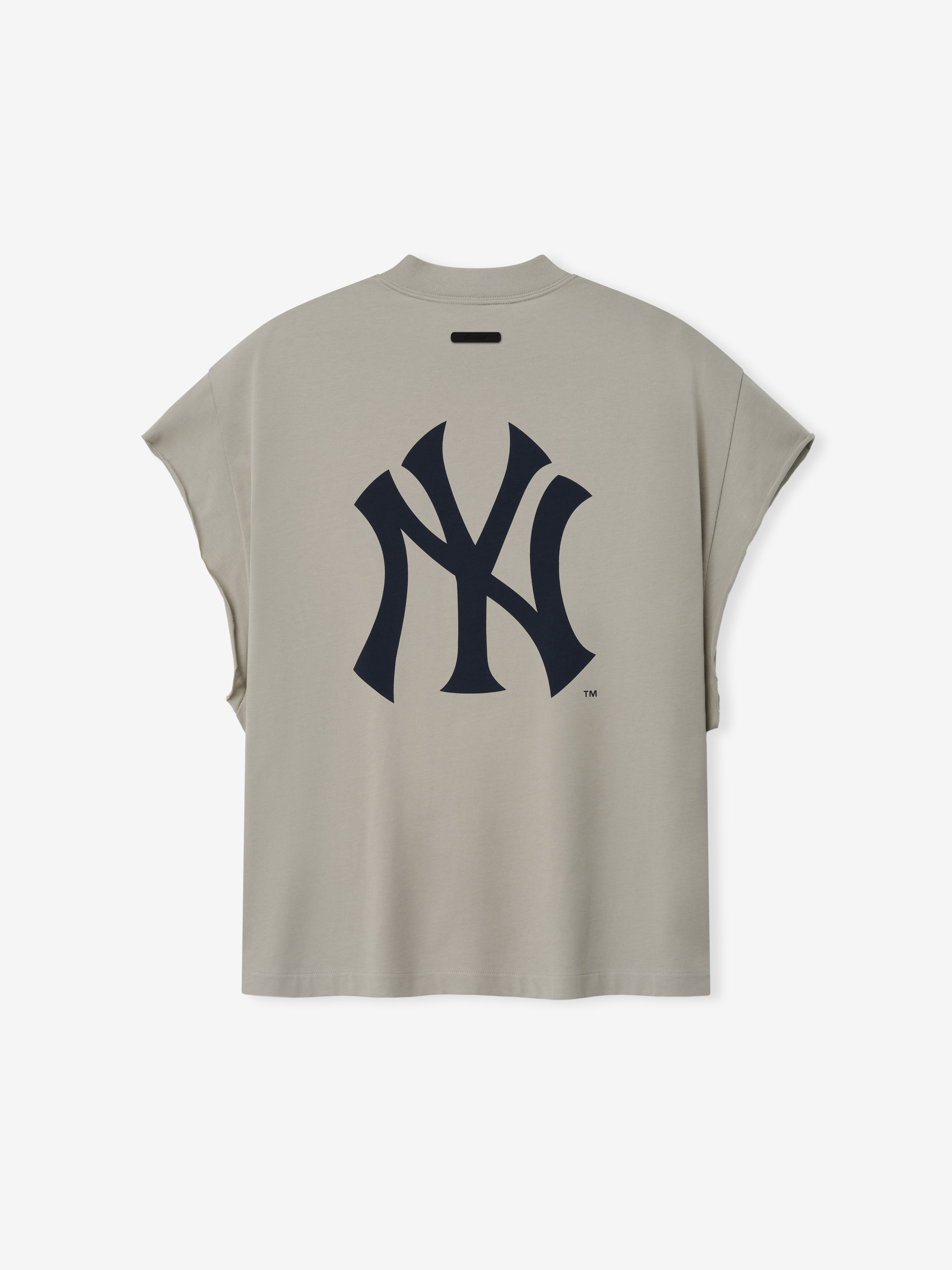 Yankees 90s Cut Off in a muted beige tone featuring a sleeveless design with wide arm openings and a large, stylized navy Yankees logo printed on the back in soft cotton fabric.