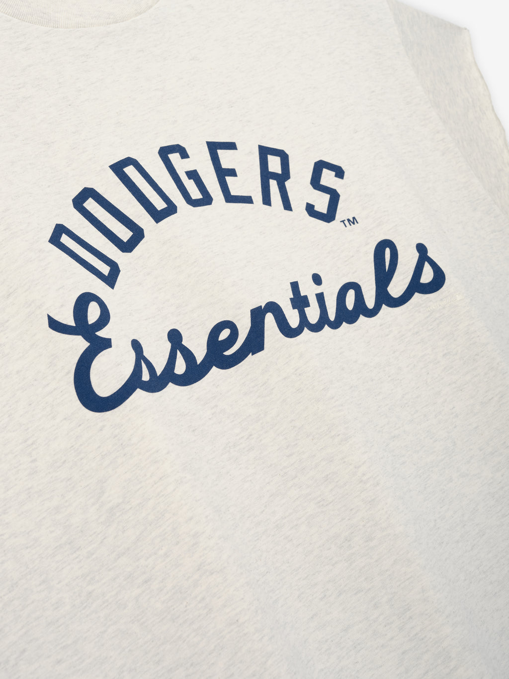 Close-up of oatmeal heather Dodgers 90s Cut Off top featuring navy blue "Dodgers Essentials" text in an arched design on soft, textured fabric.