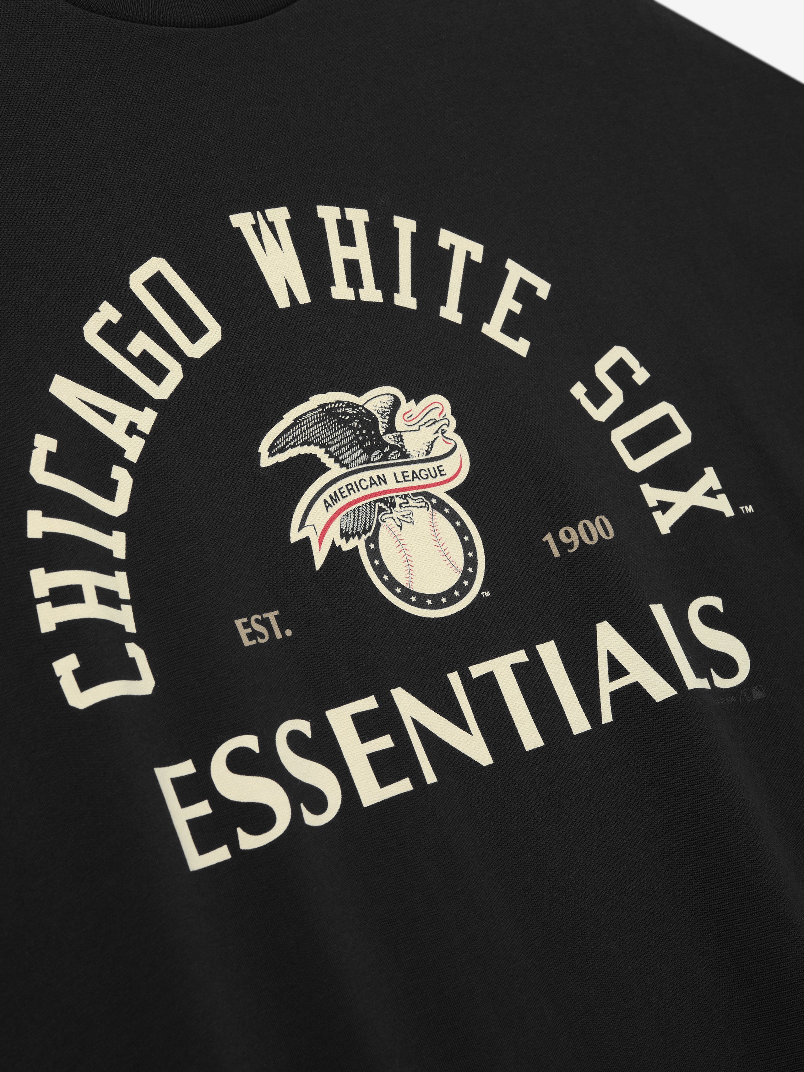 Close-up of the front of the White Sox AL Merch Tee in black, featuring a vintage-inspired Chicago White Sox graphic with an eagle, baseball, and bold "ESSENTIALS" text.