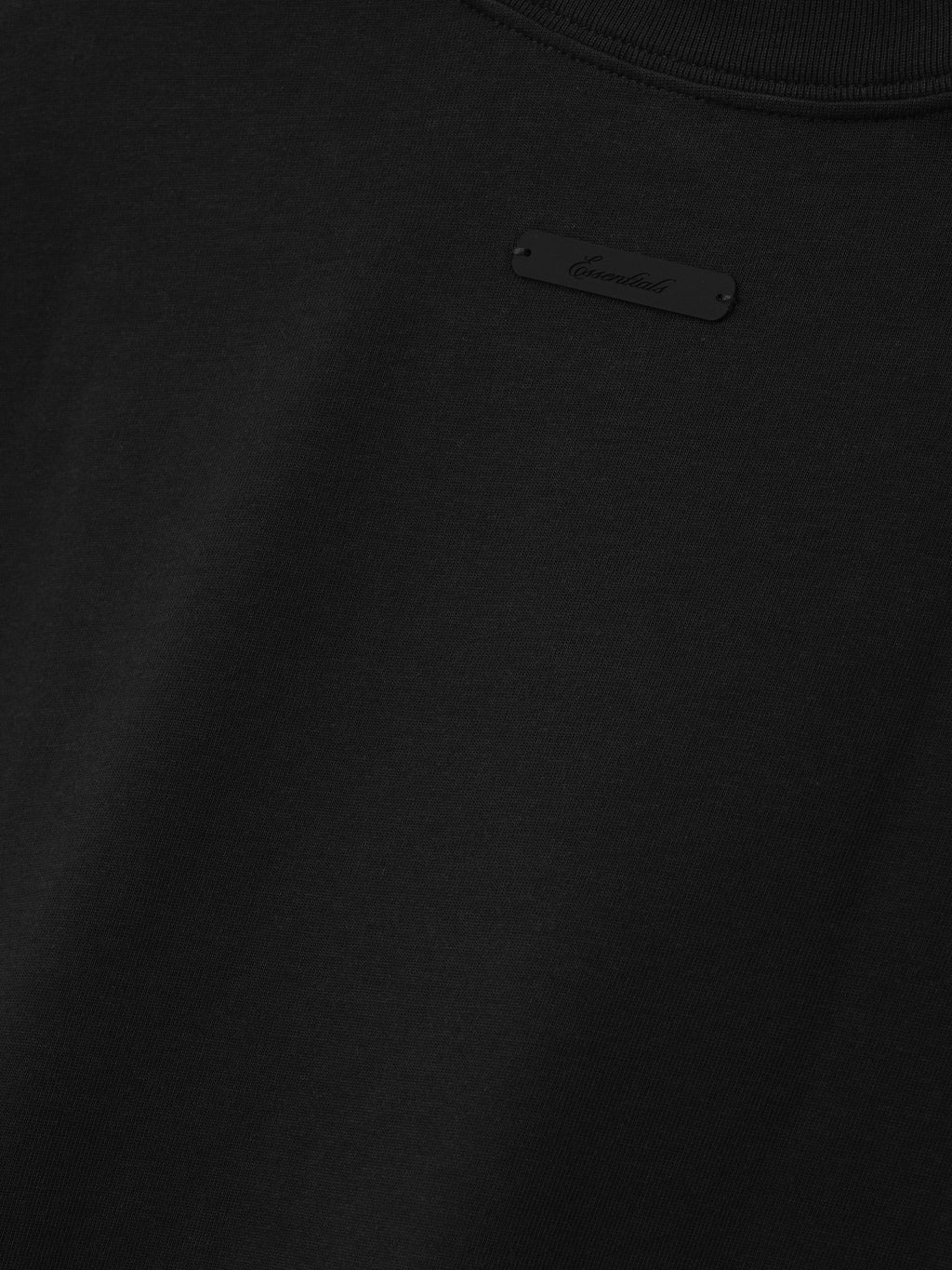 Close-up of the White Sox AL Merch Tee in black, showcasing a subtle tonal label detail on smooth cotton fabric, highlighting its minimalist streetwear design.