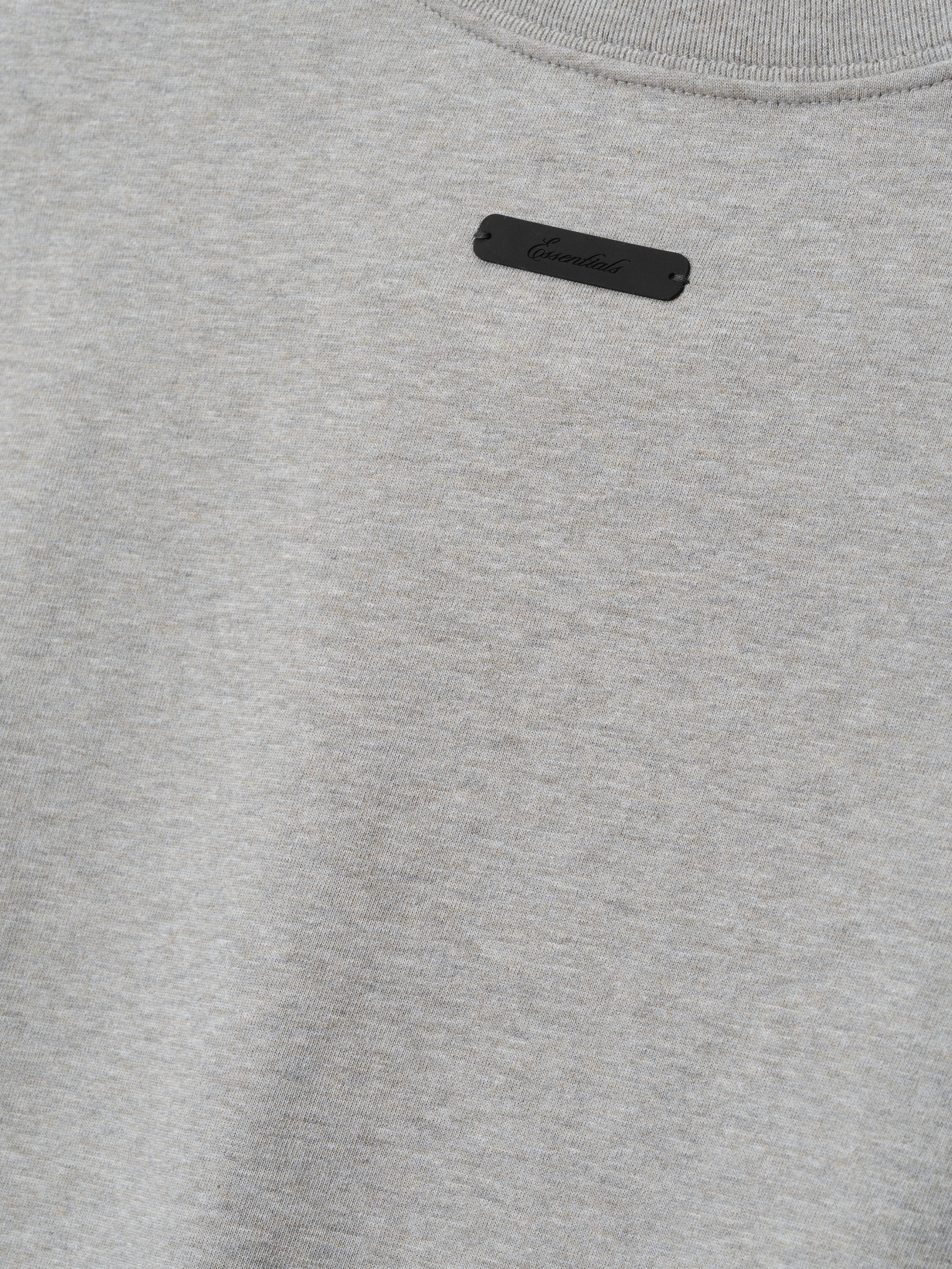 Rangers AL Merch Tee in a soft concrete heather fabric featuring a small black branded patch near the neckline, designed as a minimalist casual top.