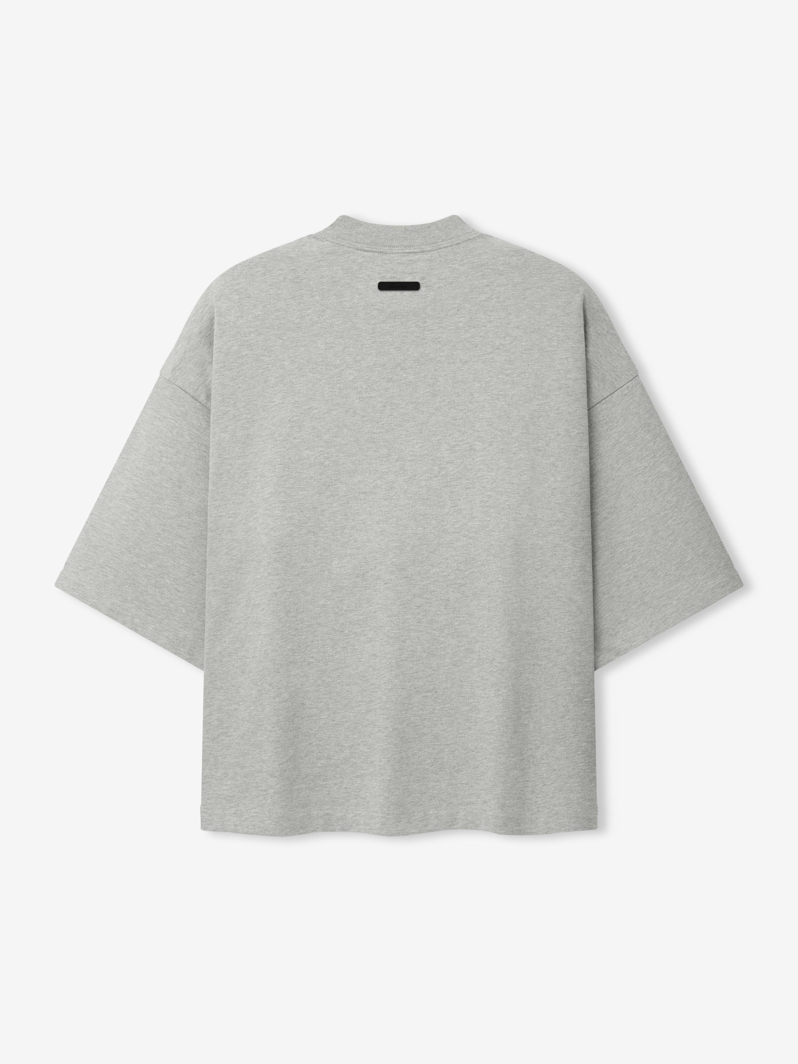 Back view of a light grey oversized short-sleeve top with dropped shoulders and a small black rectangular detail near the neckline, part of the Cubs NL Merch Tee collection.