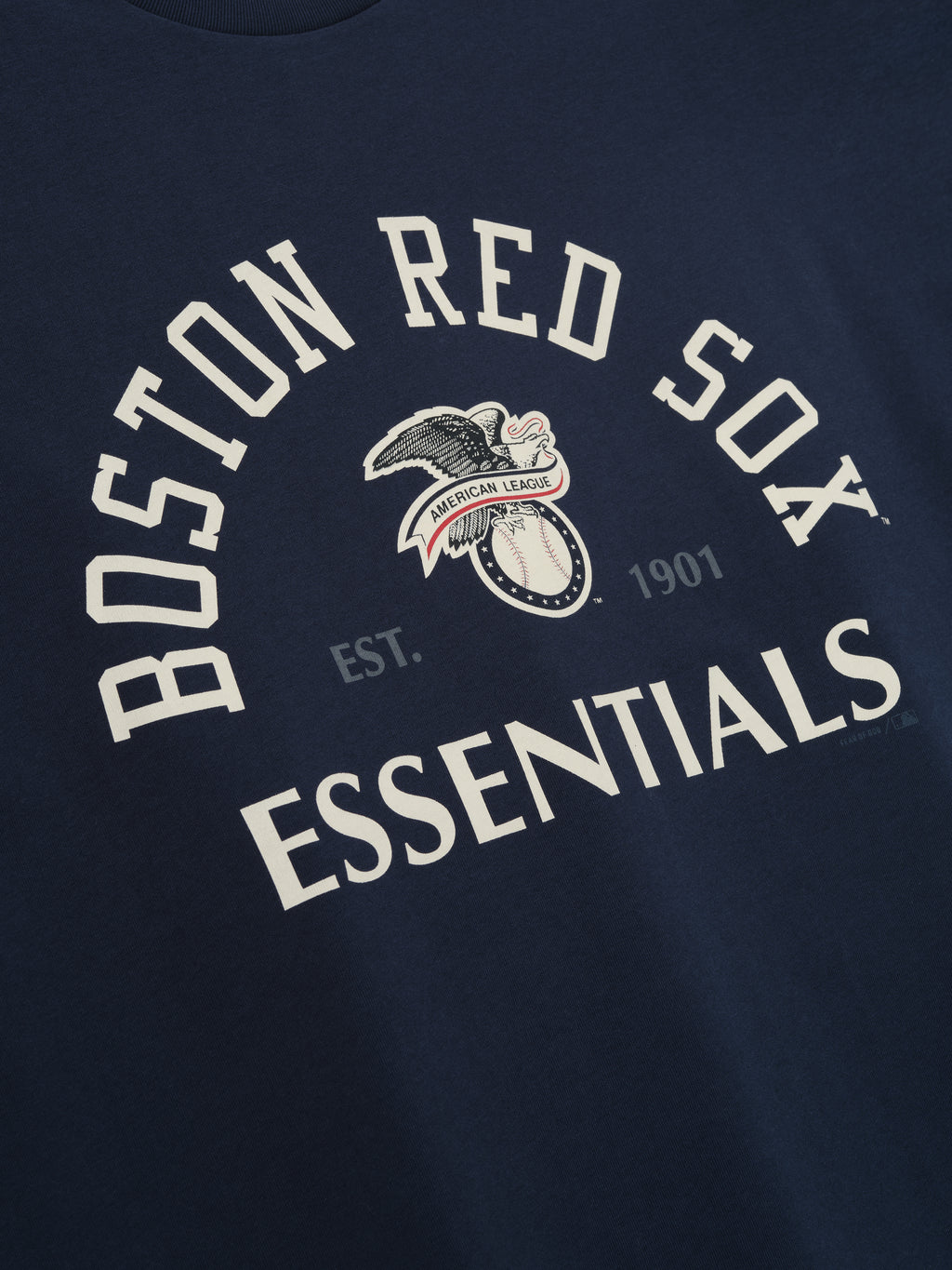 Red Sox AL Merch Tee in dark sapphire with curved "Boston Red Sox Essentials" text and vintage-style eagle and baseball graphic on soft fabric top.