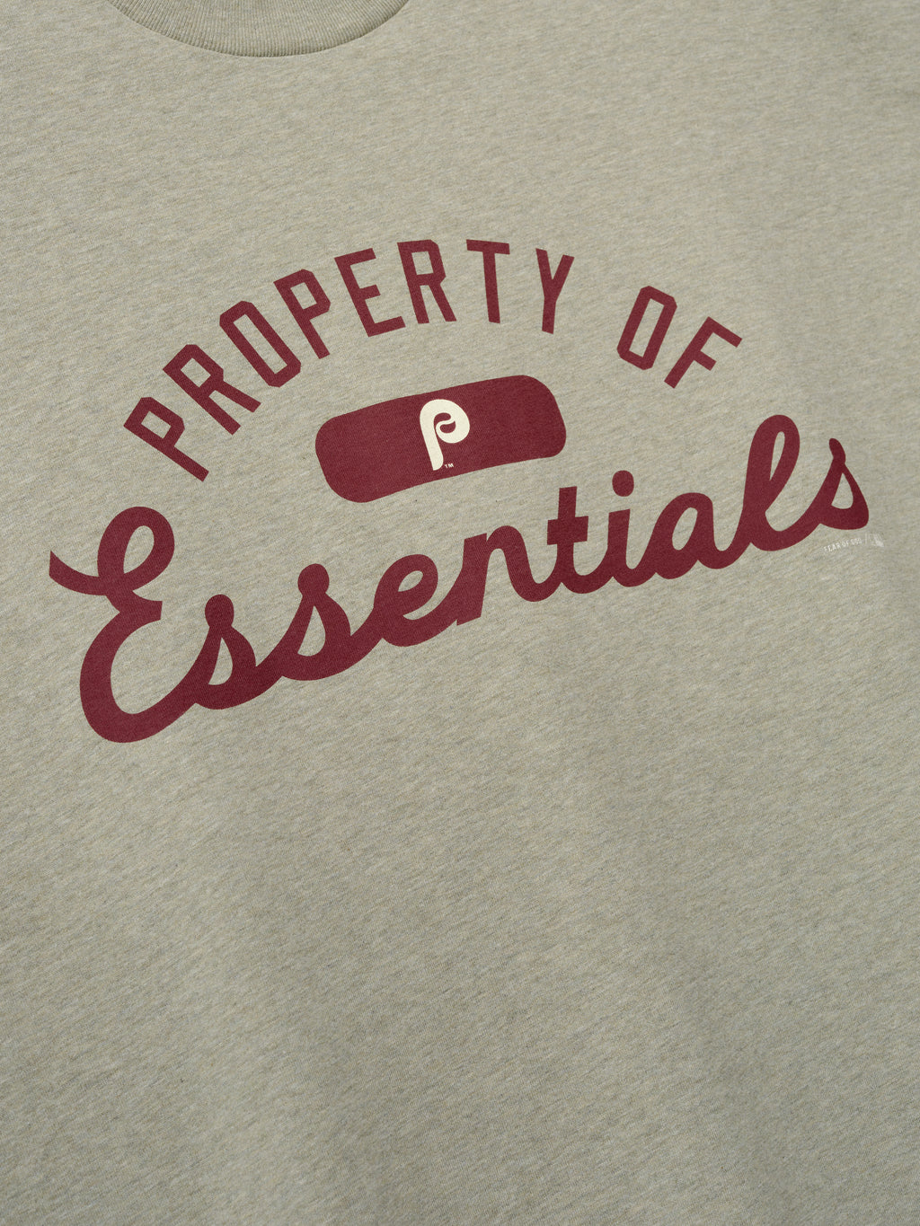 Phillies Merch Tee in a muted light gray fabric featuring maroon "Property of Essentials" text and a vintage logo centered on the chest, designed for casual everyday wear.
