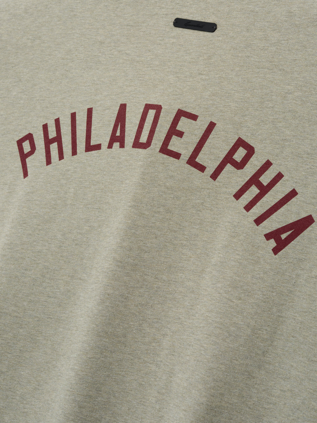 Phillies Merch Tee in a heathered light beige fabric featuring bold maroon "PHILADELPHIA" text arched across the chest, designed for a casual and comfortable fit.