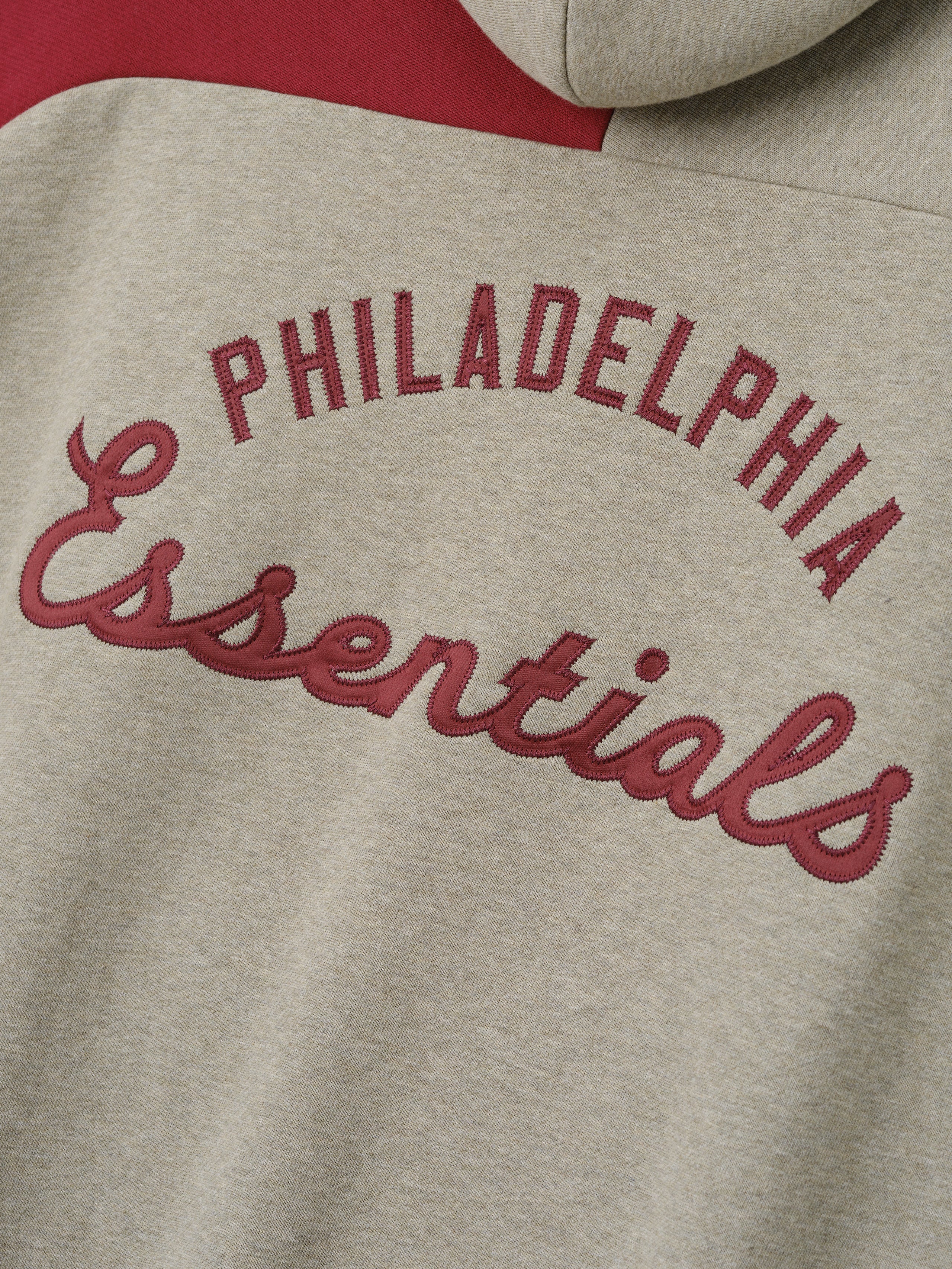 Phillies Raglan Half Zip Sport Hoodie featuring raised maroon "Philadelphia Essentials" embroidery on a soft beige fabric with a contrasting deep red panel.
