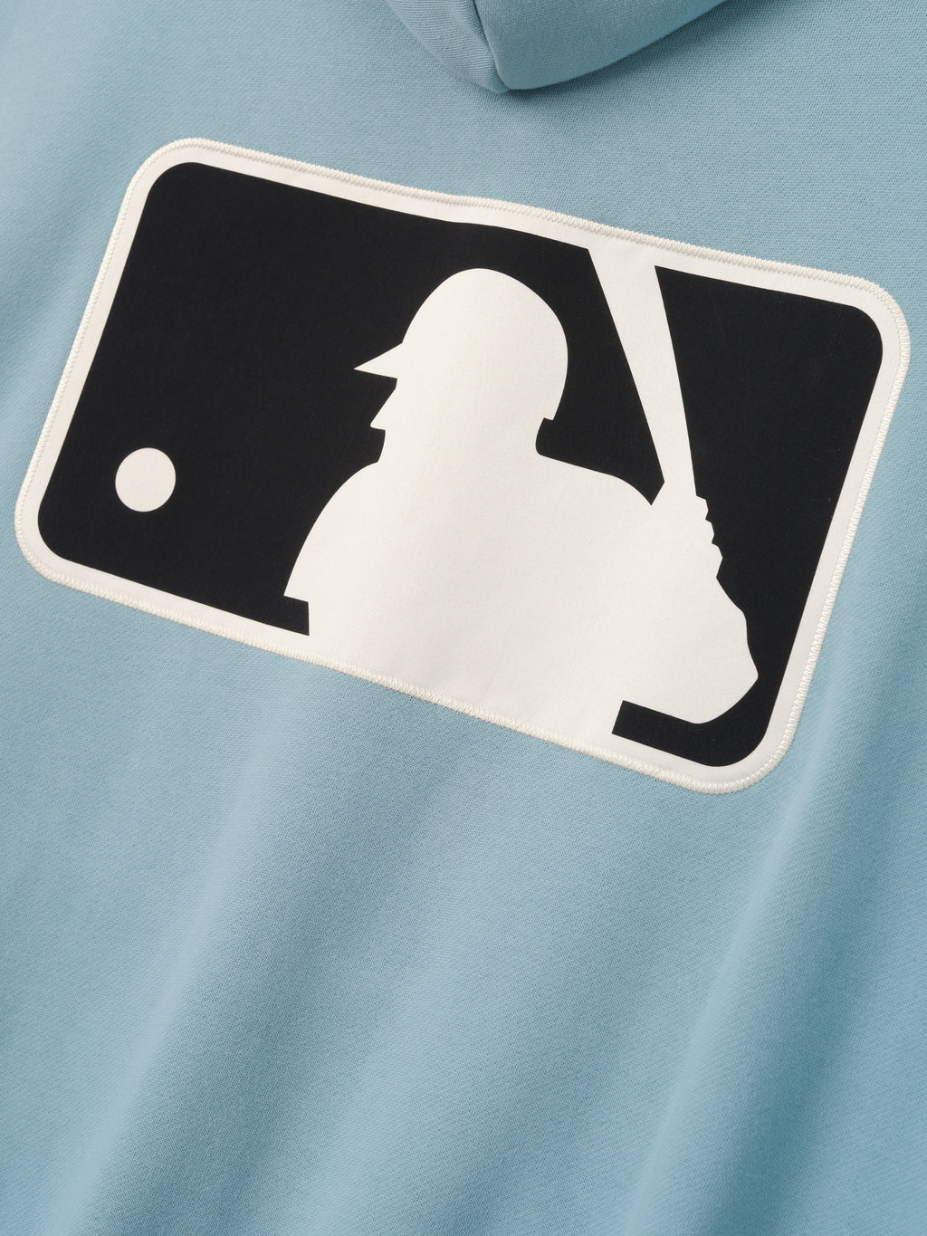 Close-up of the back of Mlb Full Zip Sport Hoodie in muted stone blue featuring a large contrasting white and black baseball batter logo patch with clean edge detailing.