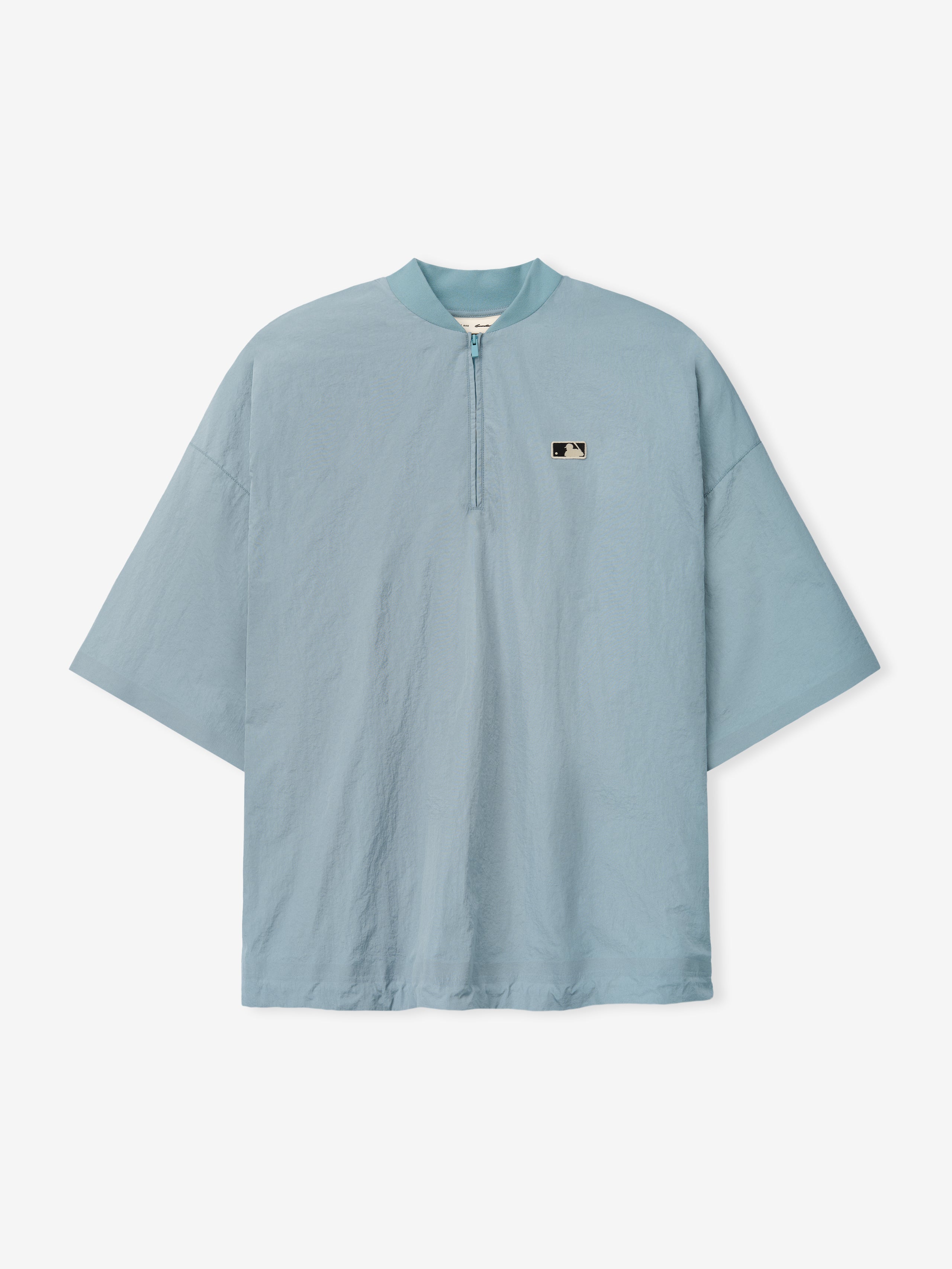 Mlb 3/4 Sleeve Pullover in a muted stone blue with a relaxed silhouette featuring a quarter-zip neckline and a small minimalist logo patch on the chest, crafted from lightweight fabric.