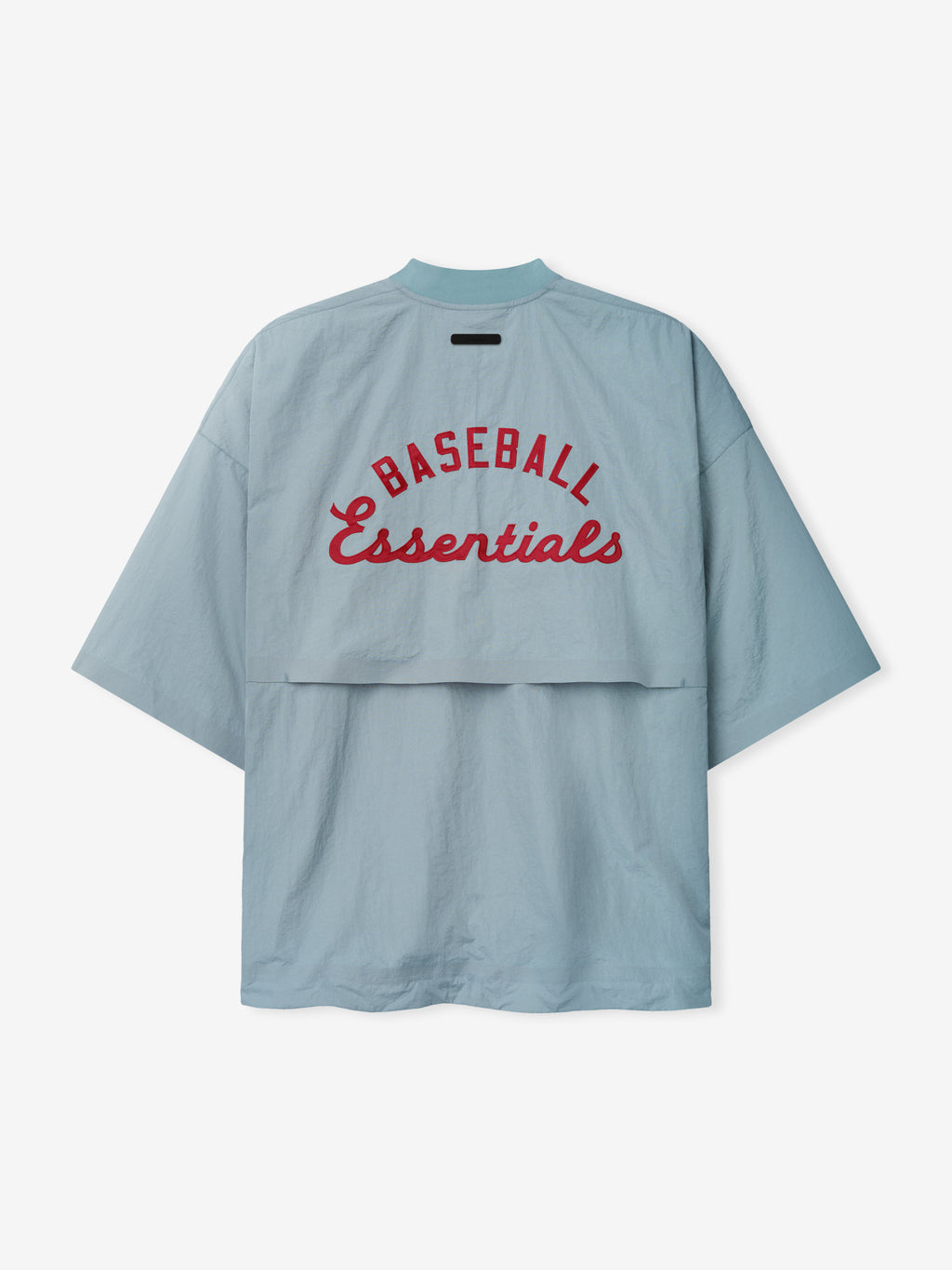Back view of the Mlb 3/4 Sleeve Pullover in soft stone blue featuring wide sleeves and red "BASEBALL Essentials" text arching across a lightweight breathable fabric top layer.