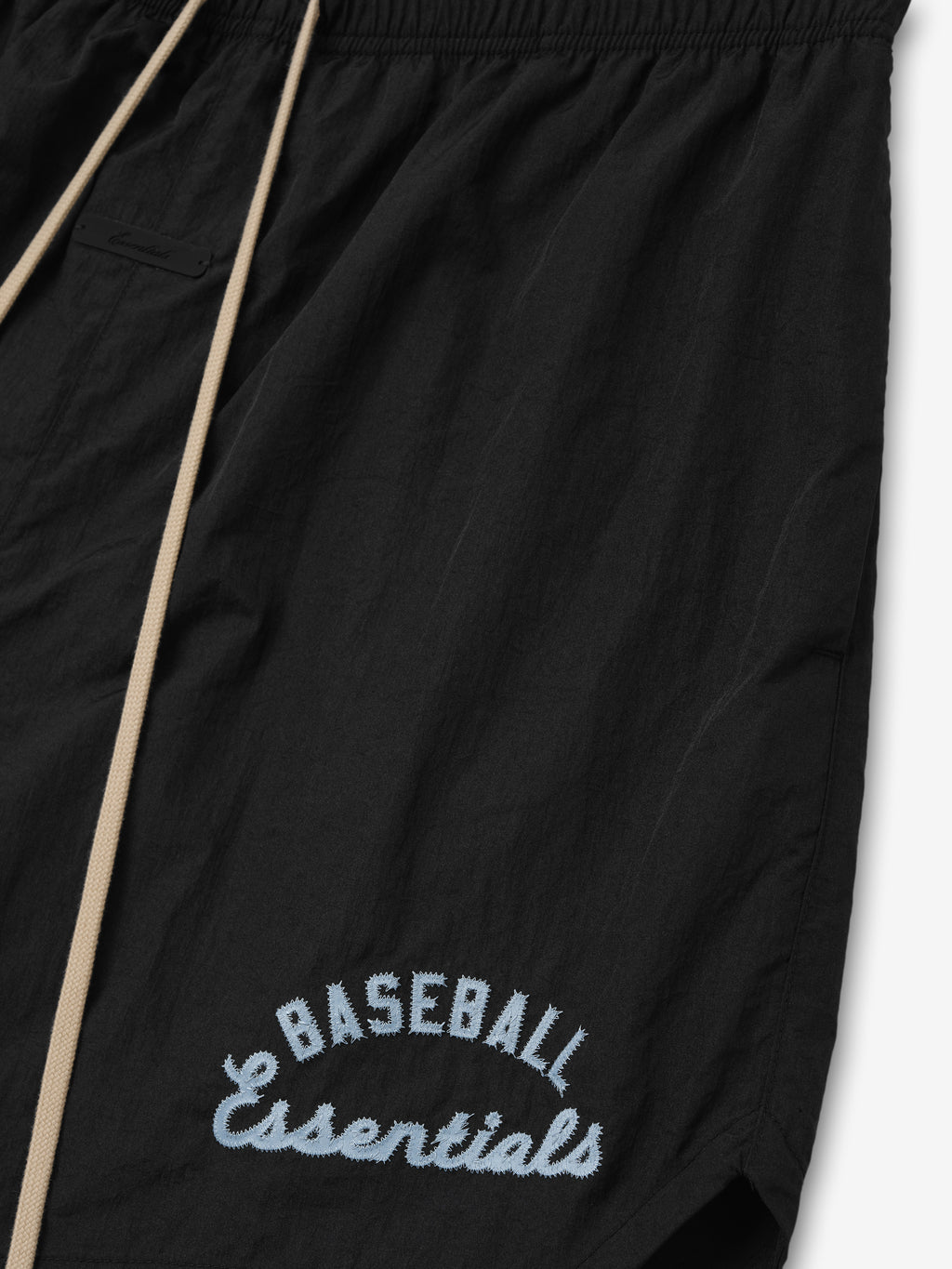 Mlb Gym Short in black featuring beige drawstrings and light blue embroidered "Baseball Essentials" text near the hem, designed for casual athletic bottoms.