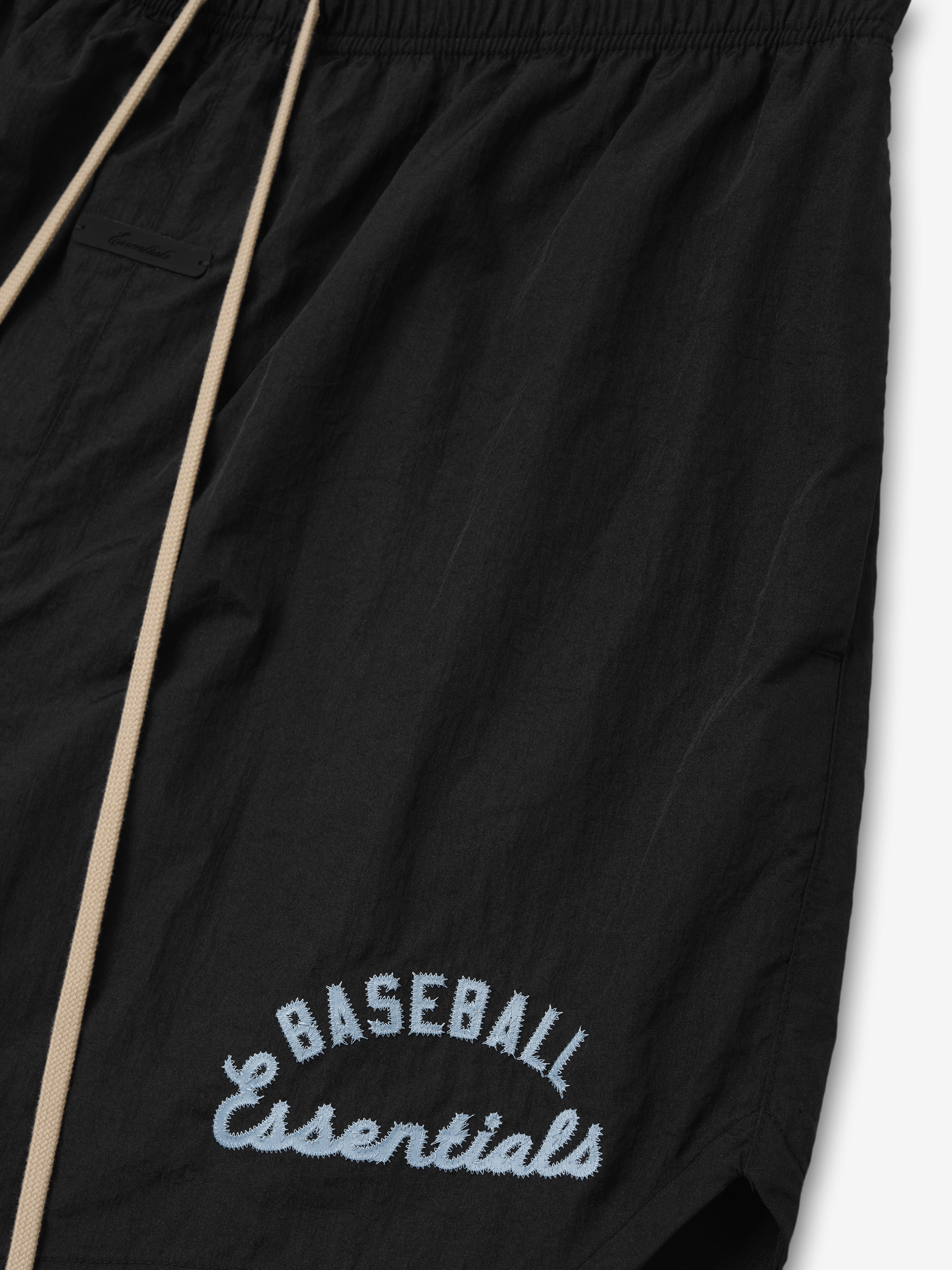 Mlb Gym Short in black featuring beige drawstrings and light blue embroidered "Baseball Essentials" text near the hem, designed for casual athletic bottoms.