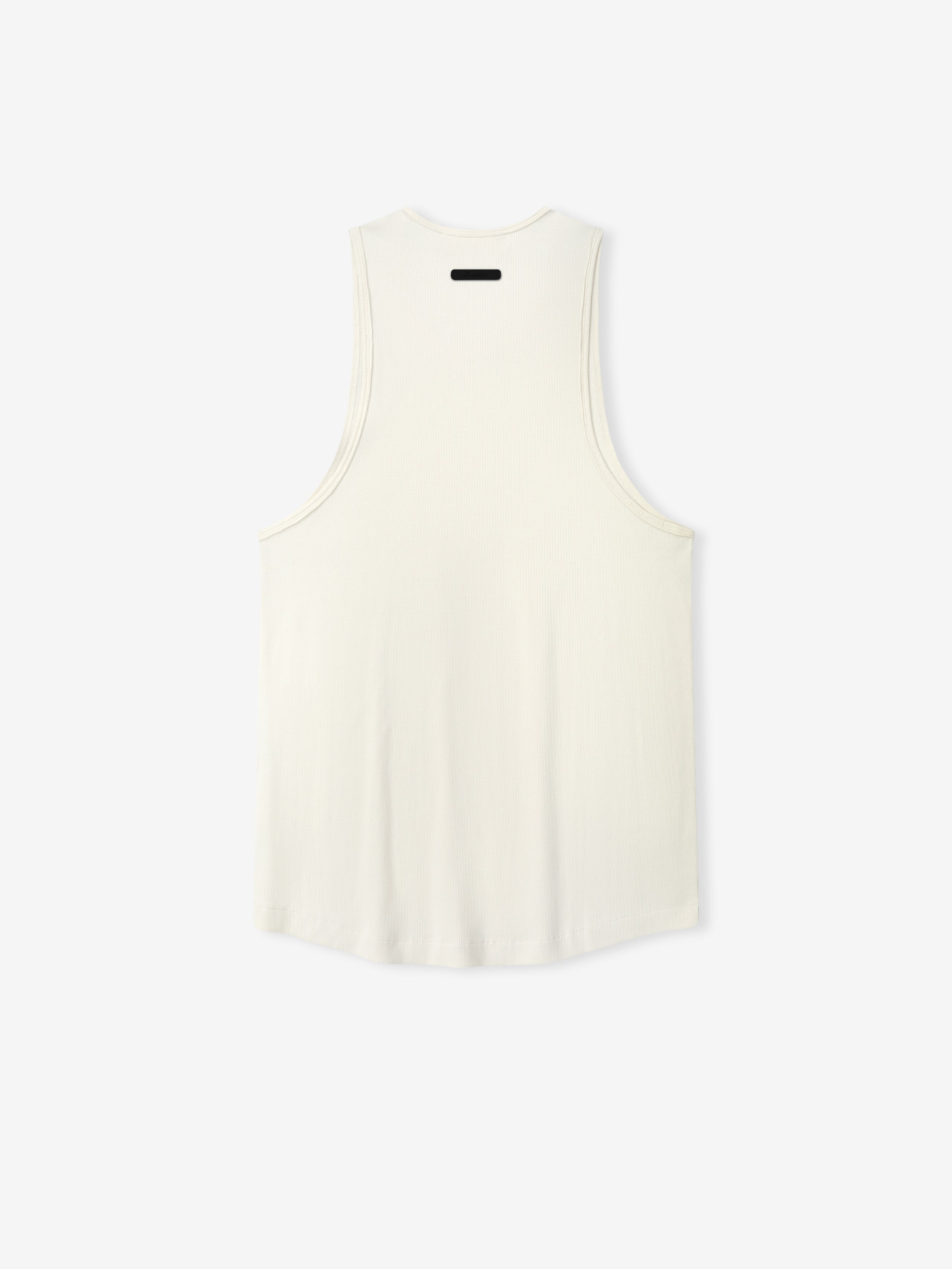 Ribbed Essential Tank in a soft ivory shade, featuring a smooth ribbed fabric with a relaxed cut and wide armholes for comfortable casual layering tops.