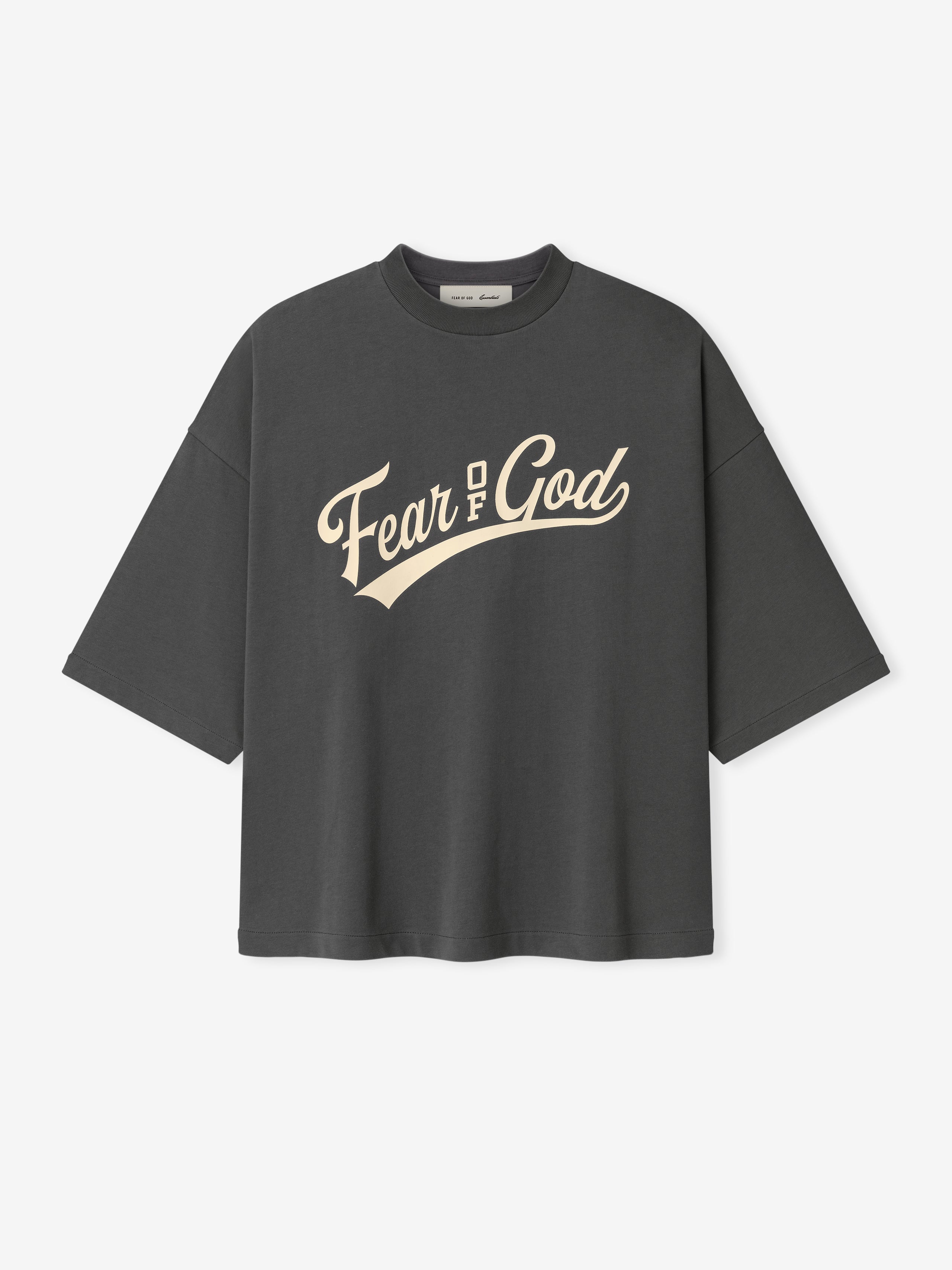 Merch Tee (Boxy) in a deep iron grey shade featuring a boxy oversized silhouette with dropped shoulders and elbow-length sleeves, printed with bold cream Fear of God lettering across the chest.
