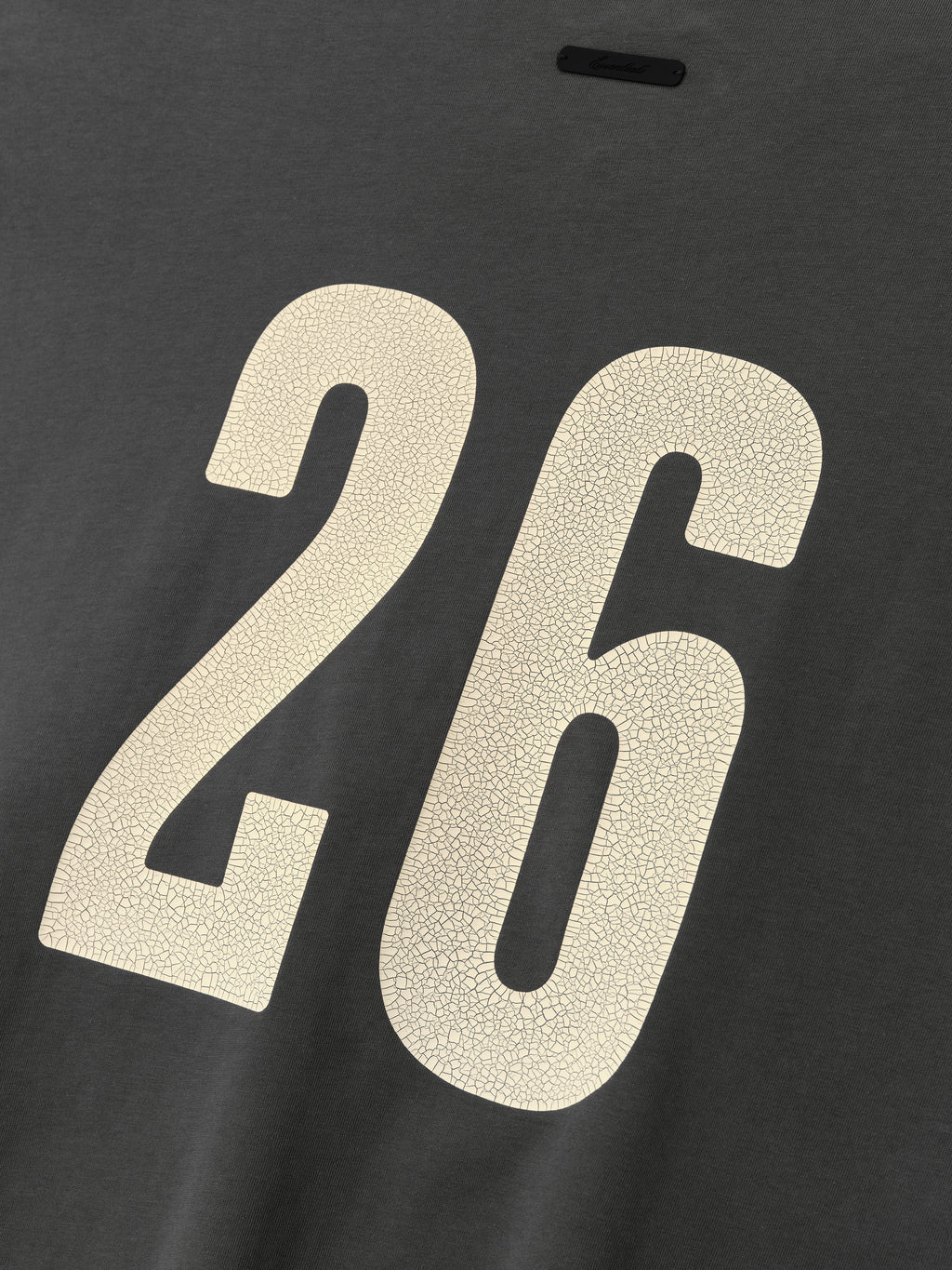Merch Tee (Boxy) in iron grey with a relaxed fit, featuring a large cream number 26 on the back with a textured, cracked finish for a vintage sporty look.