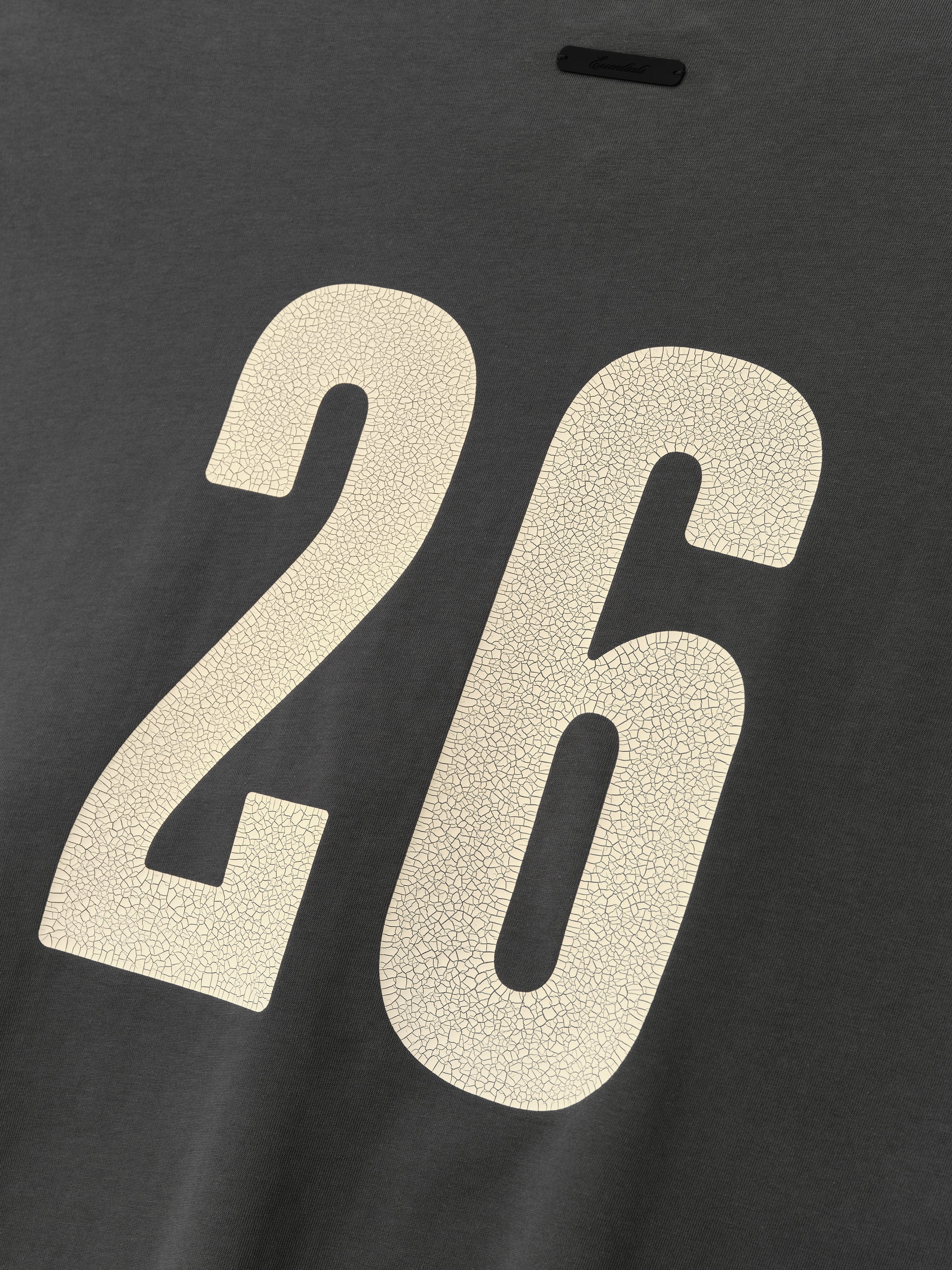 Merch Tee (Boxy) in iron grey with a relaxed fit, featuring a large cream number 26 on the back with a textured, cracked finish for a vintage sporty look.