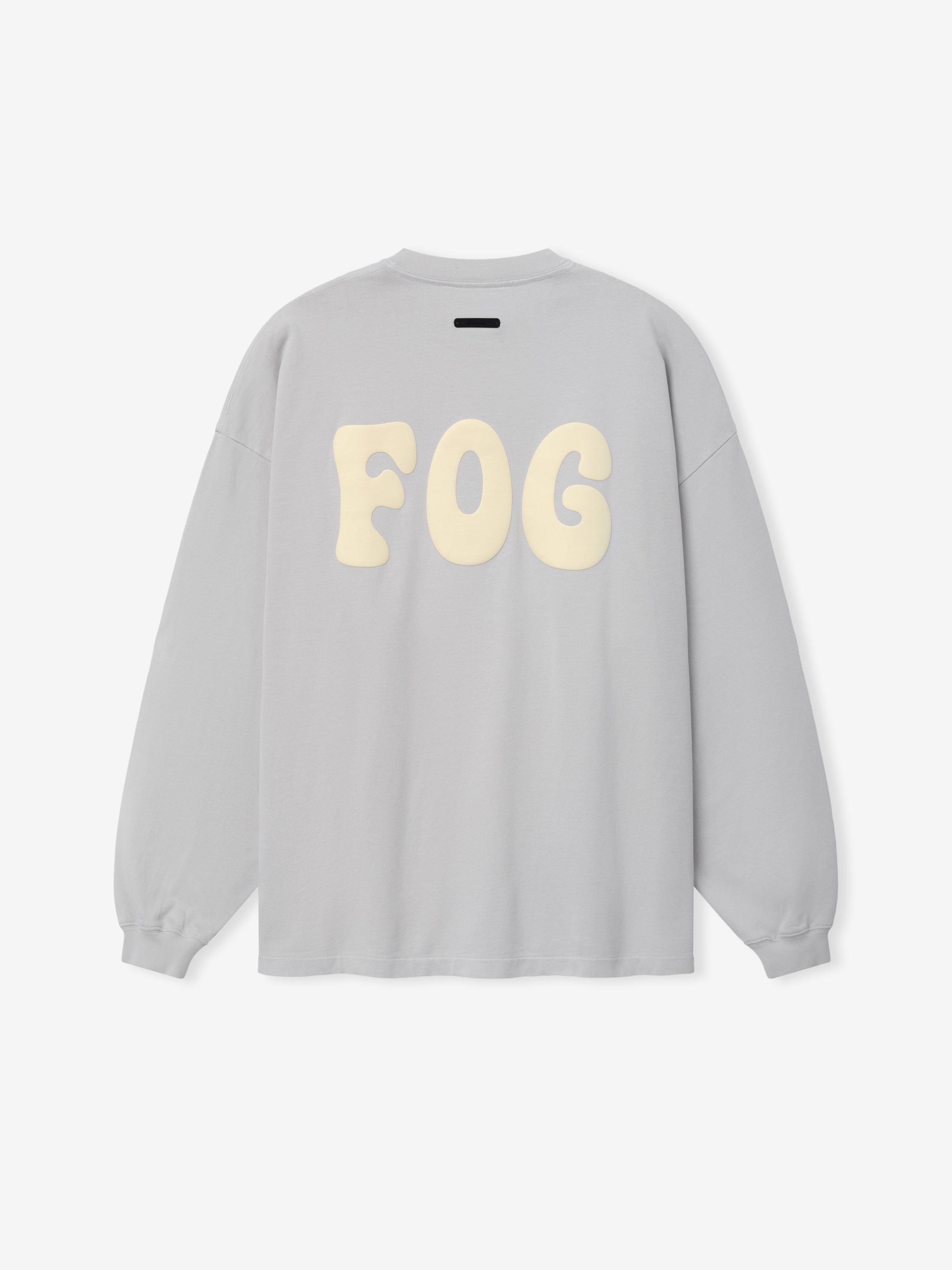 Heavy Jersey Merch Long Sleeve Tee in a light washed grey shade featuring a relaxed fit with oversized soft cream "FOG" lettering printed across the back for a clean streetwear style.