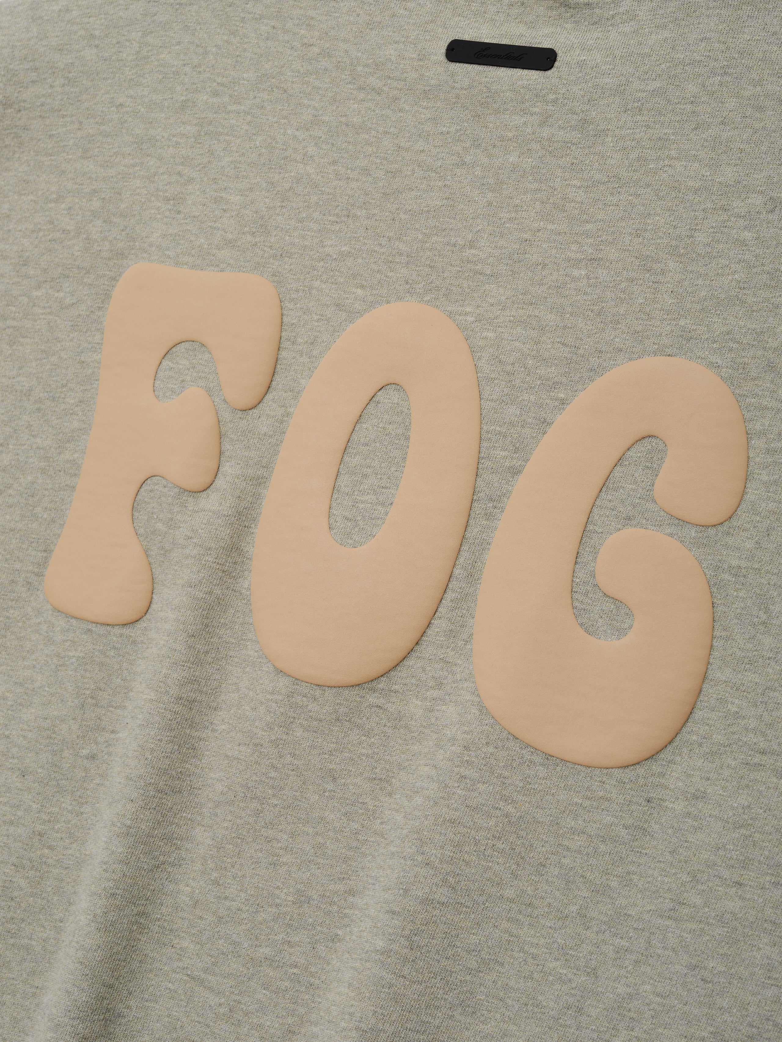 Heavy Jersey Merch Long Sleeve Tee in a soft washed seal heather fabric featuring large rounded beige "FOG" lettering with a smooth texture for a relaxed casual look.