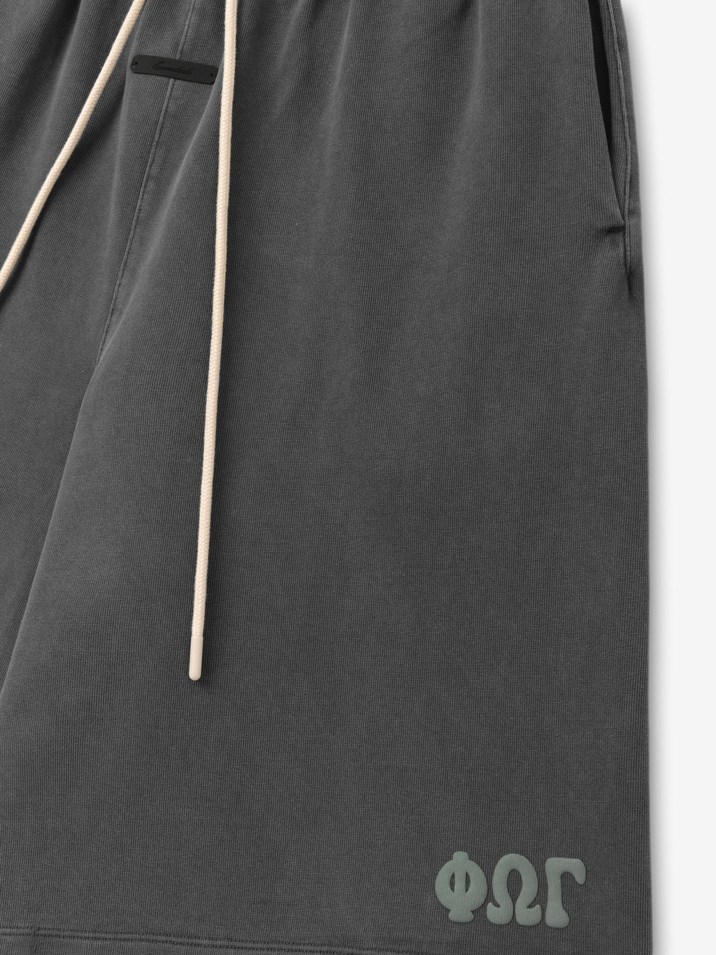 Heavy Jersey 90'S Sweatshort in washed dark grey featuring a soft fabric texture, contrasting cream drawstrings, side pockets, and a small tonal logo near the hem on casual bottoms.