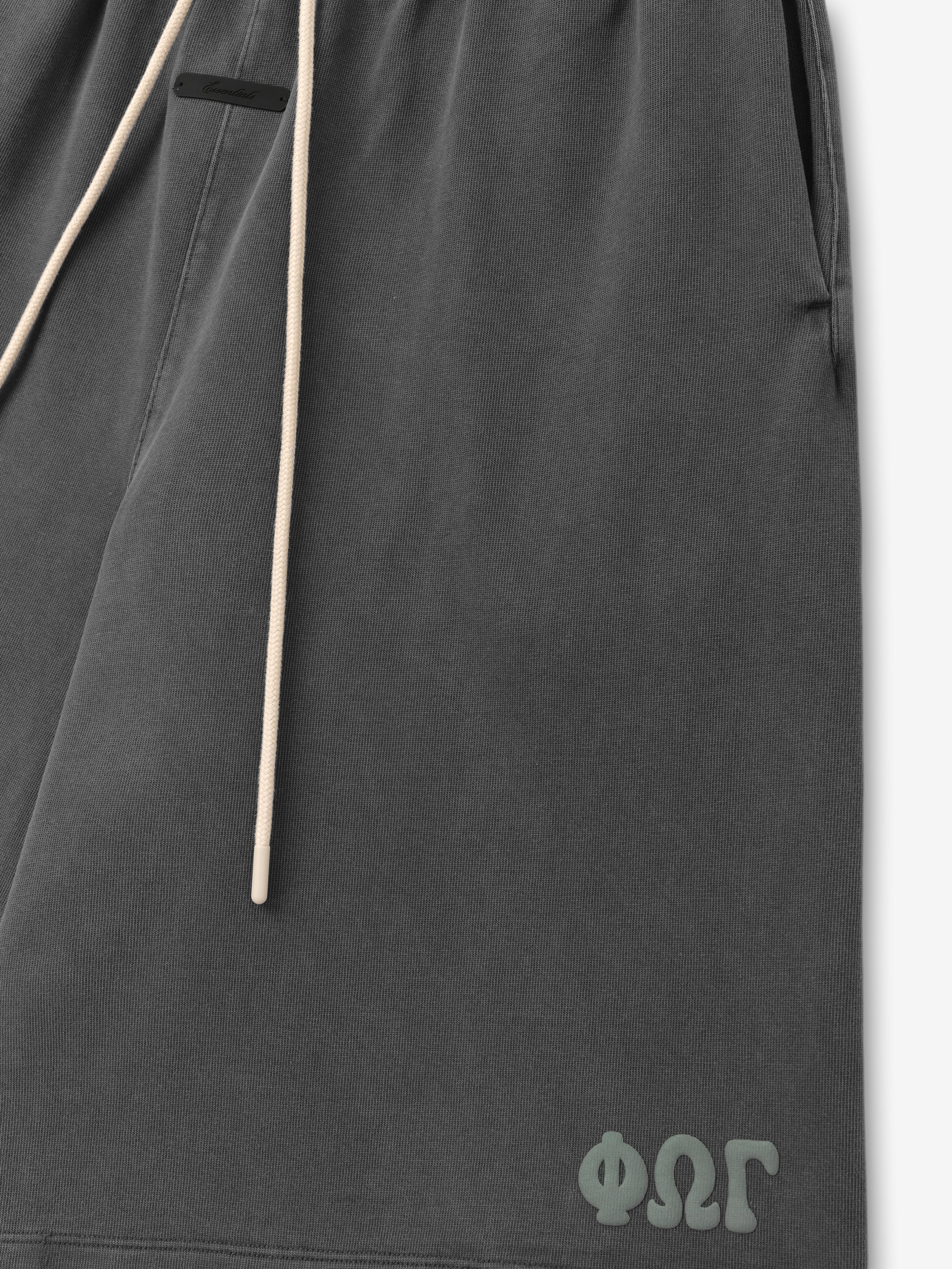 Heavy Jersey 90'S Sweatshort in washed dark grey featuring a soft fabric texture, contrasting cream drawstrings, side pockets, and a small tonal logo near the hem on casual bottoms.