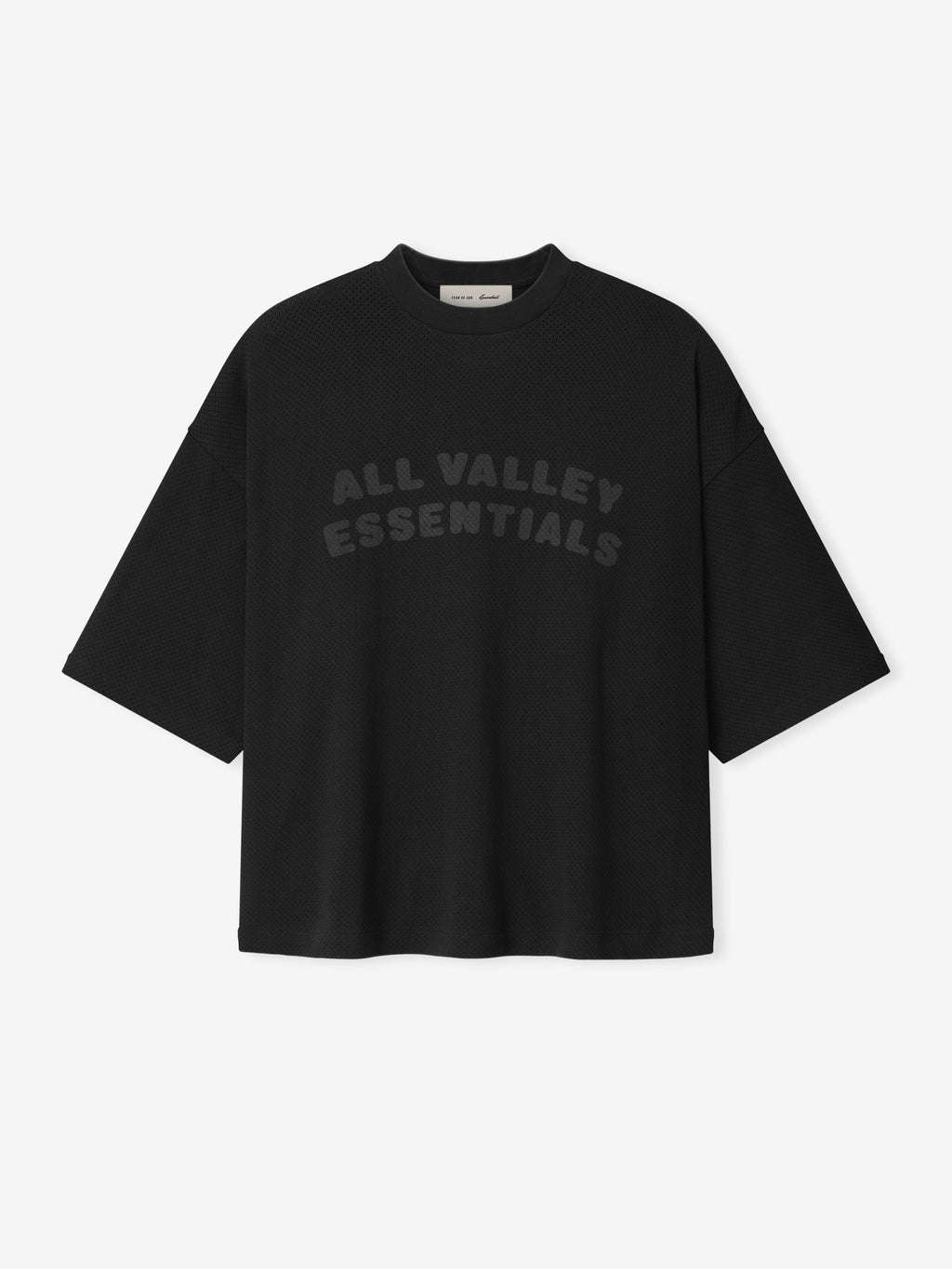Sport Mesh Merch Tee in vintage black with a relaxed fit, featuring subtle tonal "ALL VALLEY ESSENTIALS" text on breathable mesh fabric for a modern casual top.