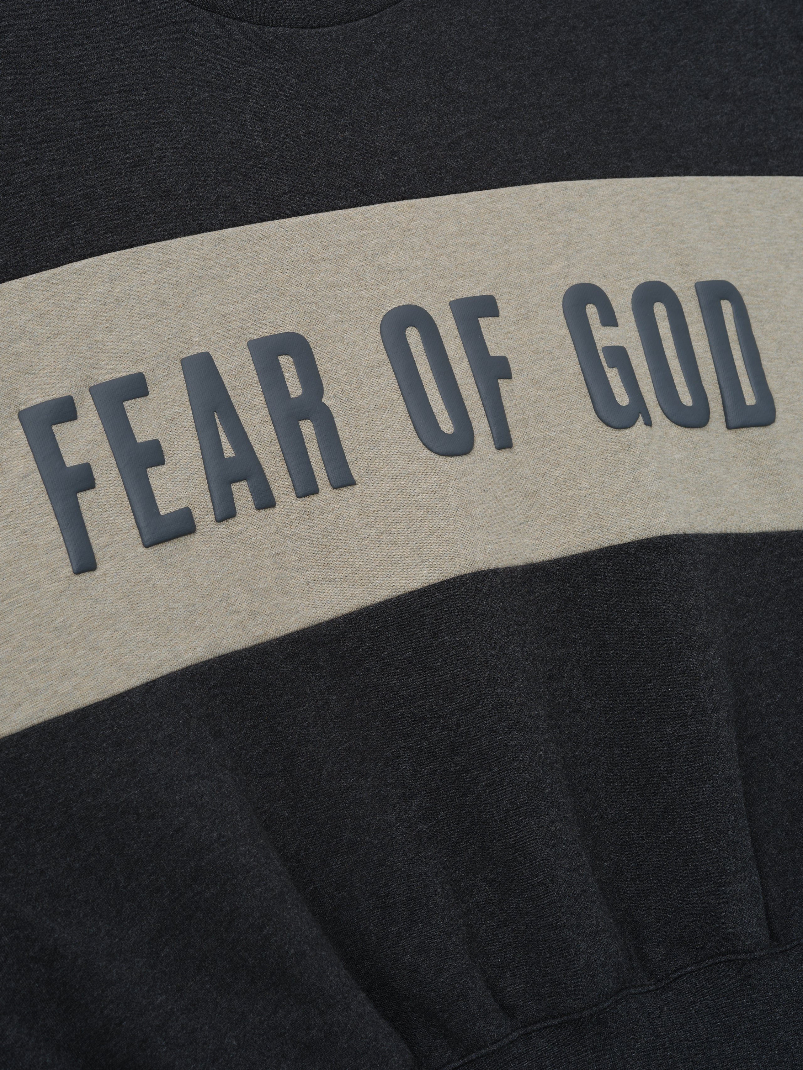Cropped Relaxed Panelled Sweatshirt featuring a dark grey base with a wide contrasting muted beige horizontal panel across the chest displaying raised dark grey Fear of God lettering for a casual, contemporary look.