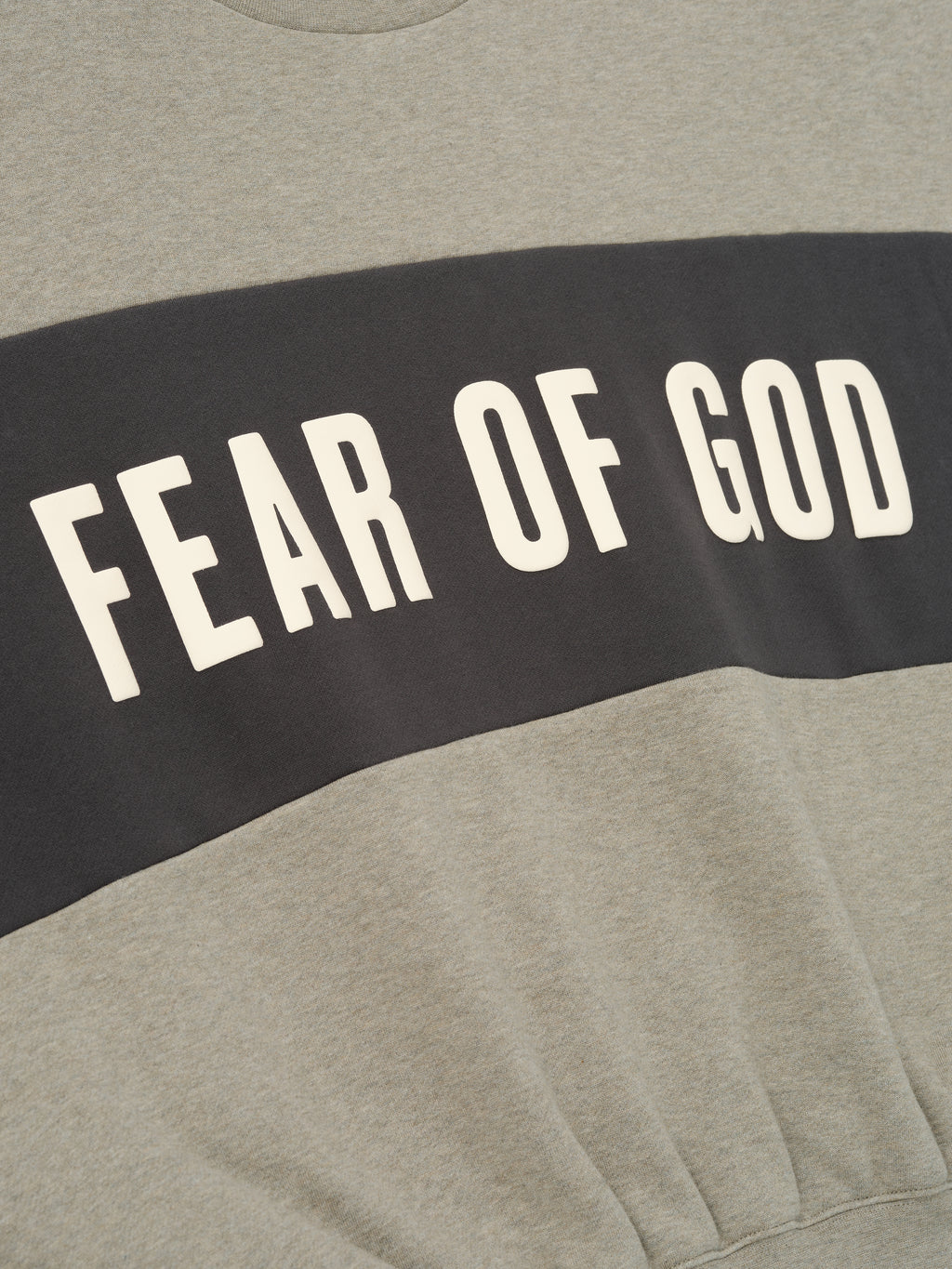Cropped Relaxed Panelled Sweatshirt in soft heather grey with a contrasting dark panel across the chest featuring bold cream Fear of God lettering for an elevated streetwear look.