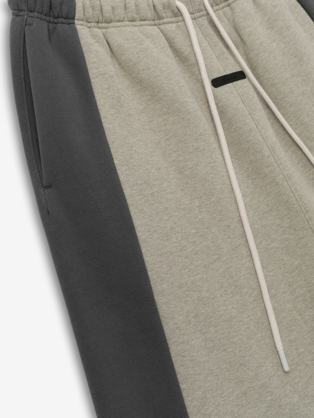 Panelled Lounge Pant crafted in a soft fabric with a muted beige center and contrasting dark grey side panels, featuring an elastic waistband and adjustable drawstring for a comfortable fit.