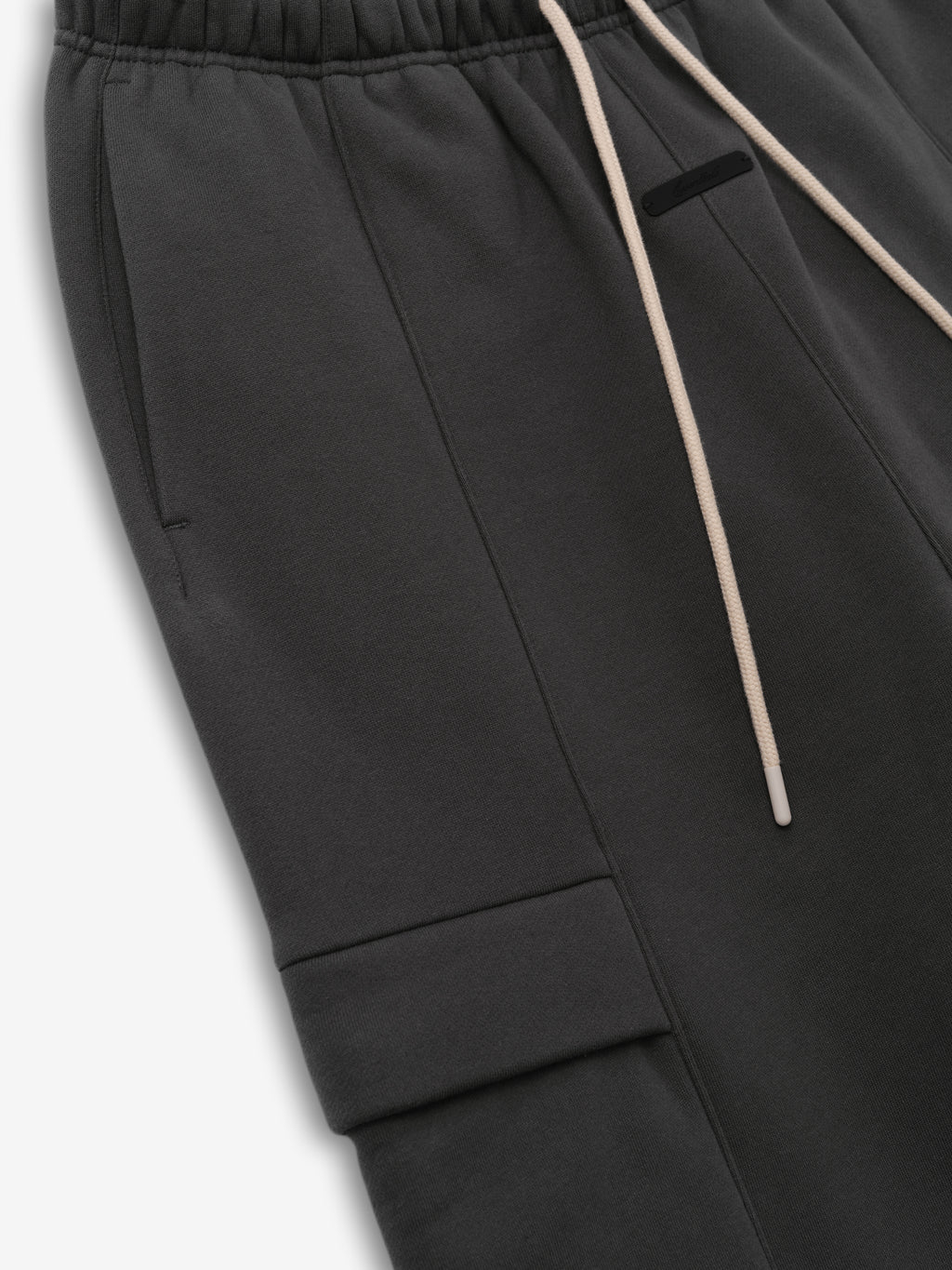 Fleece Cargo Field Pant in charcoal grey featuring an elastic waistband with beige drawstrings and a streamlined cargo pocket for a modern, comfortable bottoms choice.