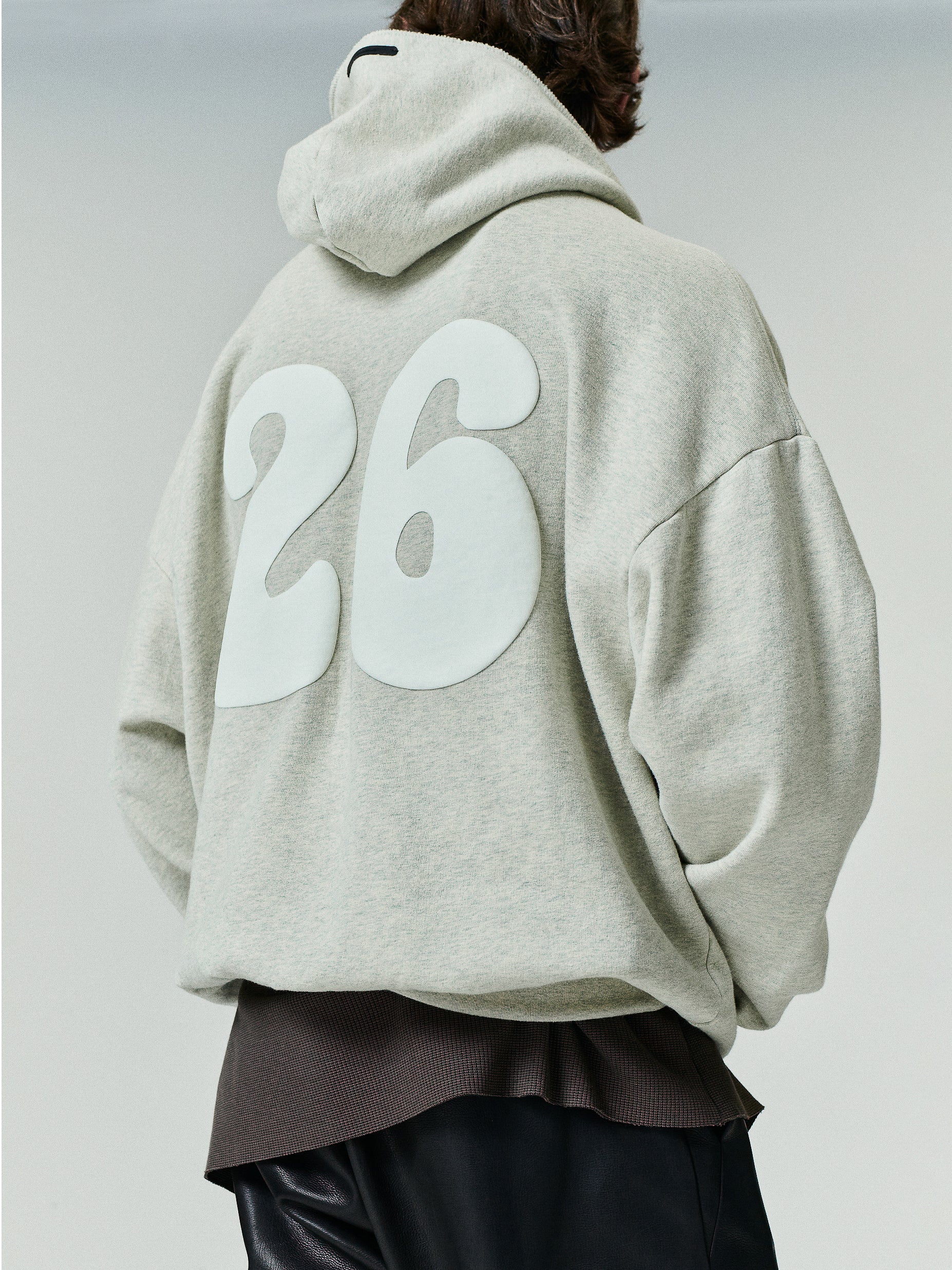 90'S Zip-Up Hoodie in a light neutral tone featuring an oversized fit with dropped shoulders and large bold white numbers printed on the back.