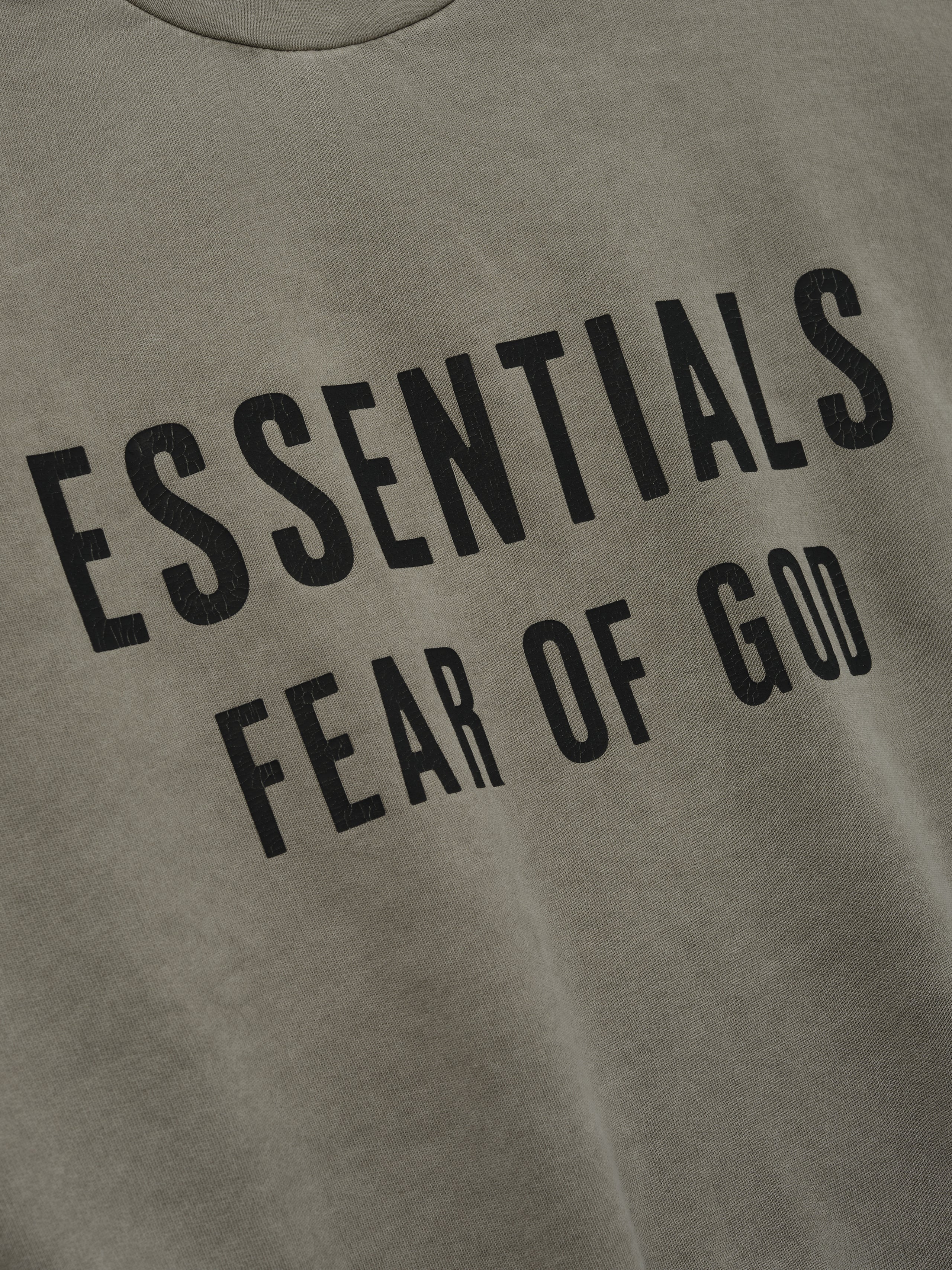 Relaxed Fleece Cutoff Sweatshirt in a muted seal green shade, featuring bold black Essentials Fear of God lettering on soft fleece fabric for a stylish streetwear top.