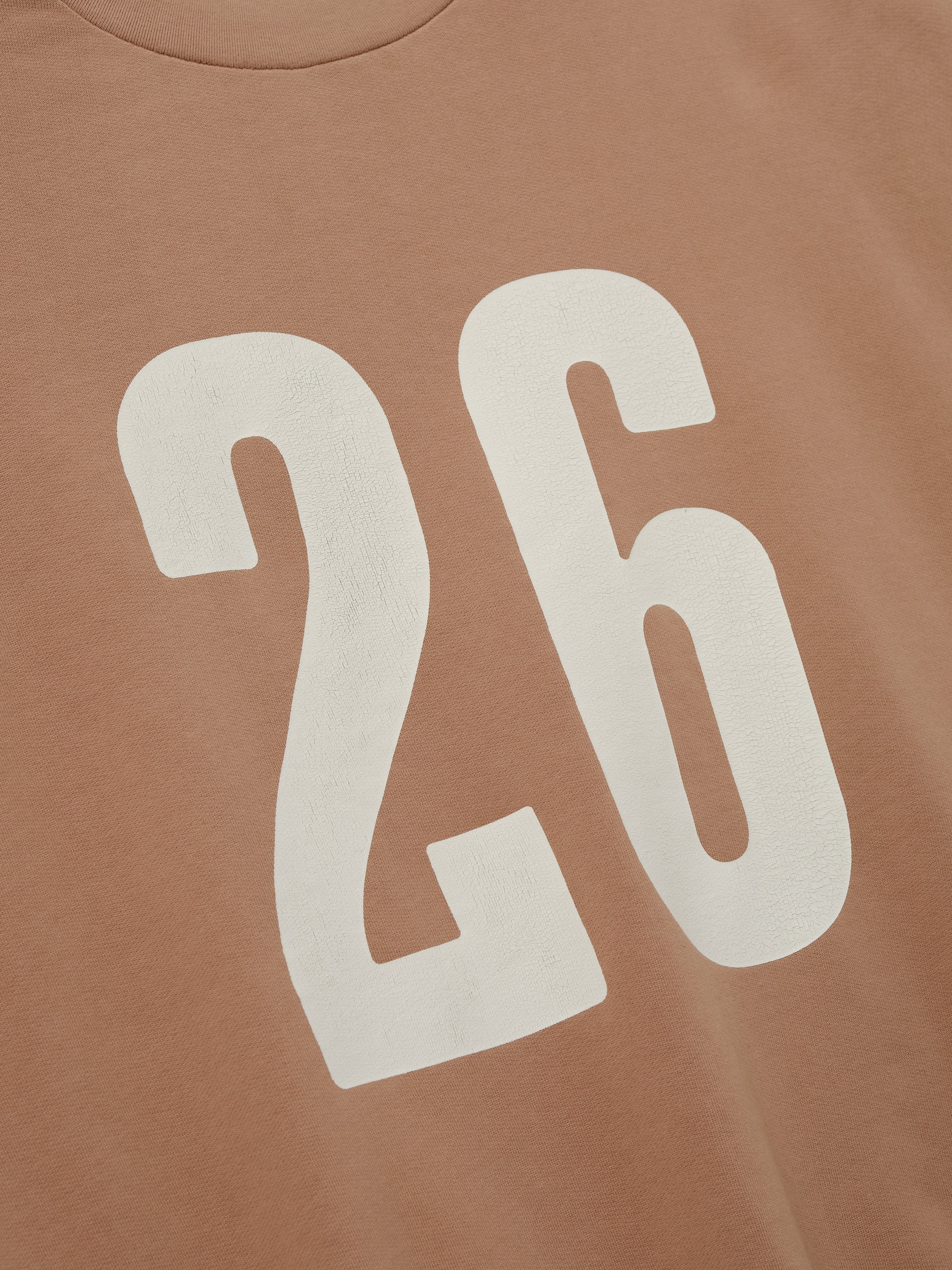 Close-up of a washed ginger 3/4 Sleeve Crewneck showing large, bold white number "26" printed on the front, highlighting soft fabric and casual sporty details.