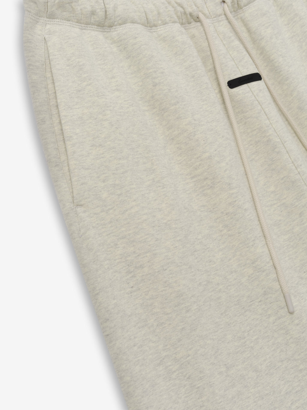 Flare Sweatpant in a soft washed vanilla heather fabric featuring an elastic waistband with drawstrings and side pockets, designed as comfortable and stylish casual bottoms.