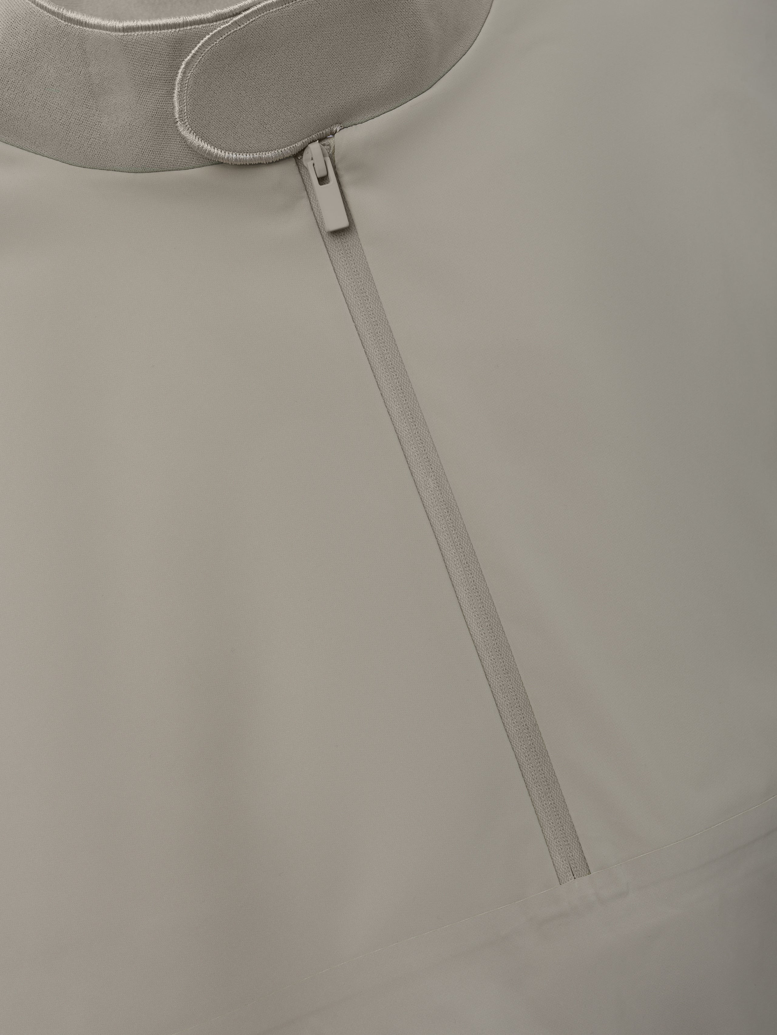 Half Zip Track Jacket in a muted neutral tone featuring a sleek front zipper and smooth fabric texture for a minimalist, modern outerwear option.