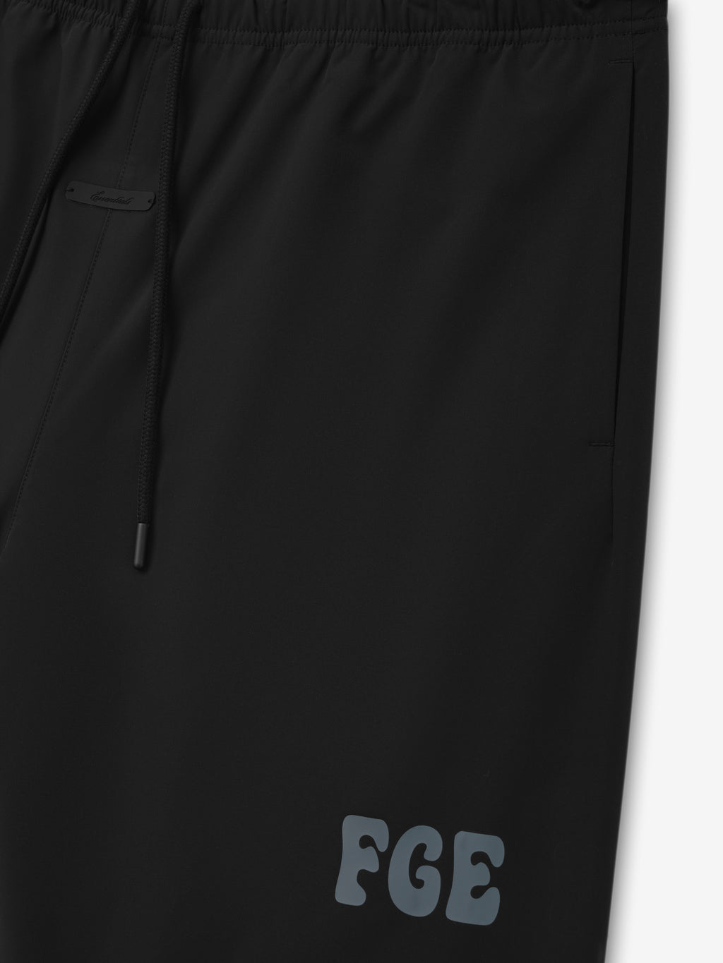 Storm Pant in a vintage black color with an elastic waistband, adjustable drawstrings, side pockets, and subtle "FGE" logo detailing on the thigh for a modern casual look.