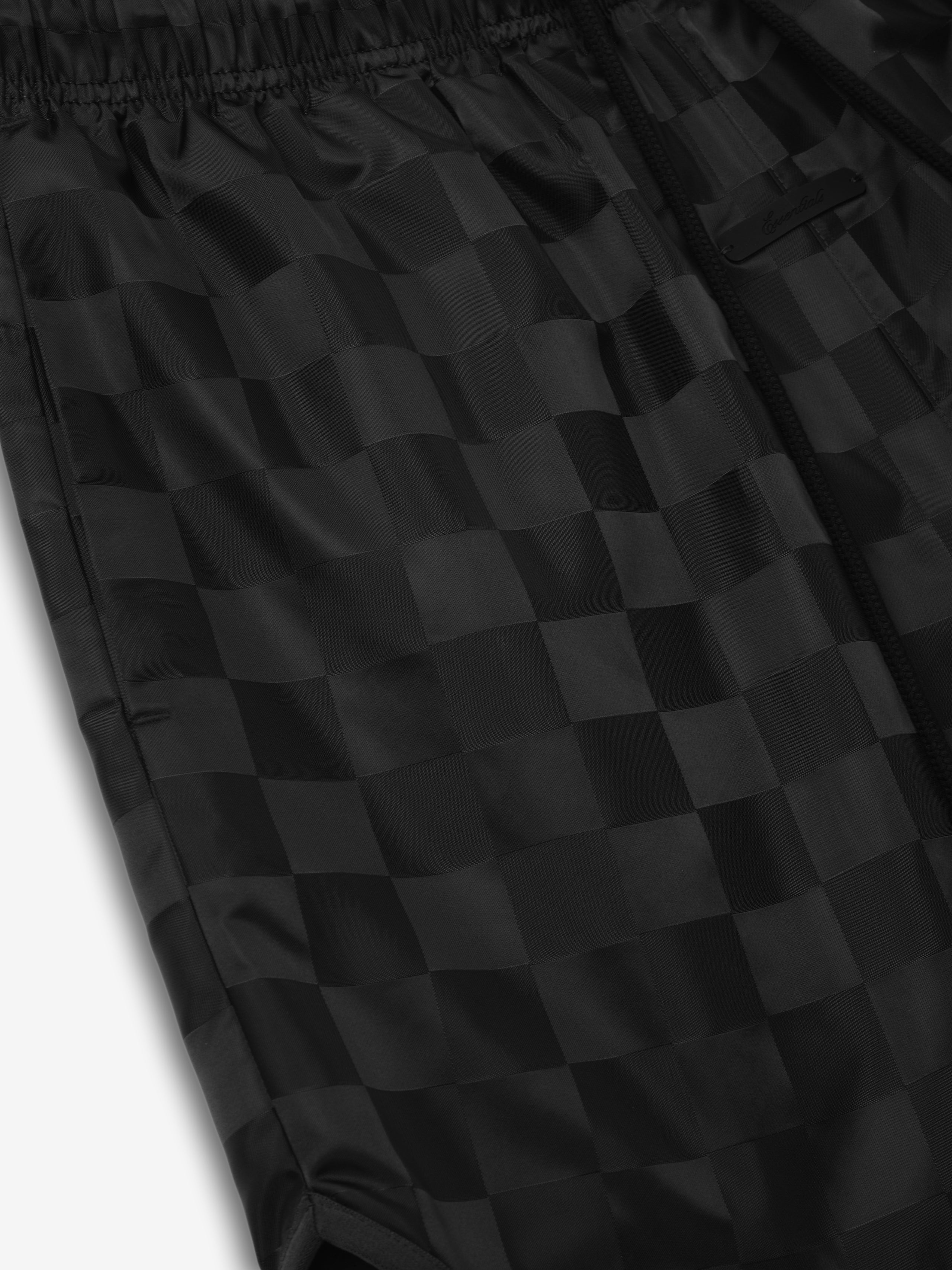 Nylon Checkered Gym Short in a deep black shade featuring a subtle checkered pattern, elastic waistband, and side zip pocket for stylish and functional athletic bottoms.